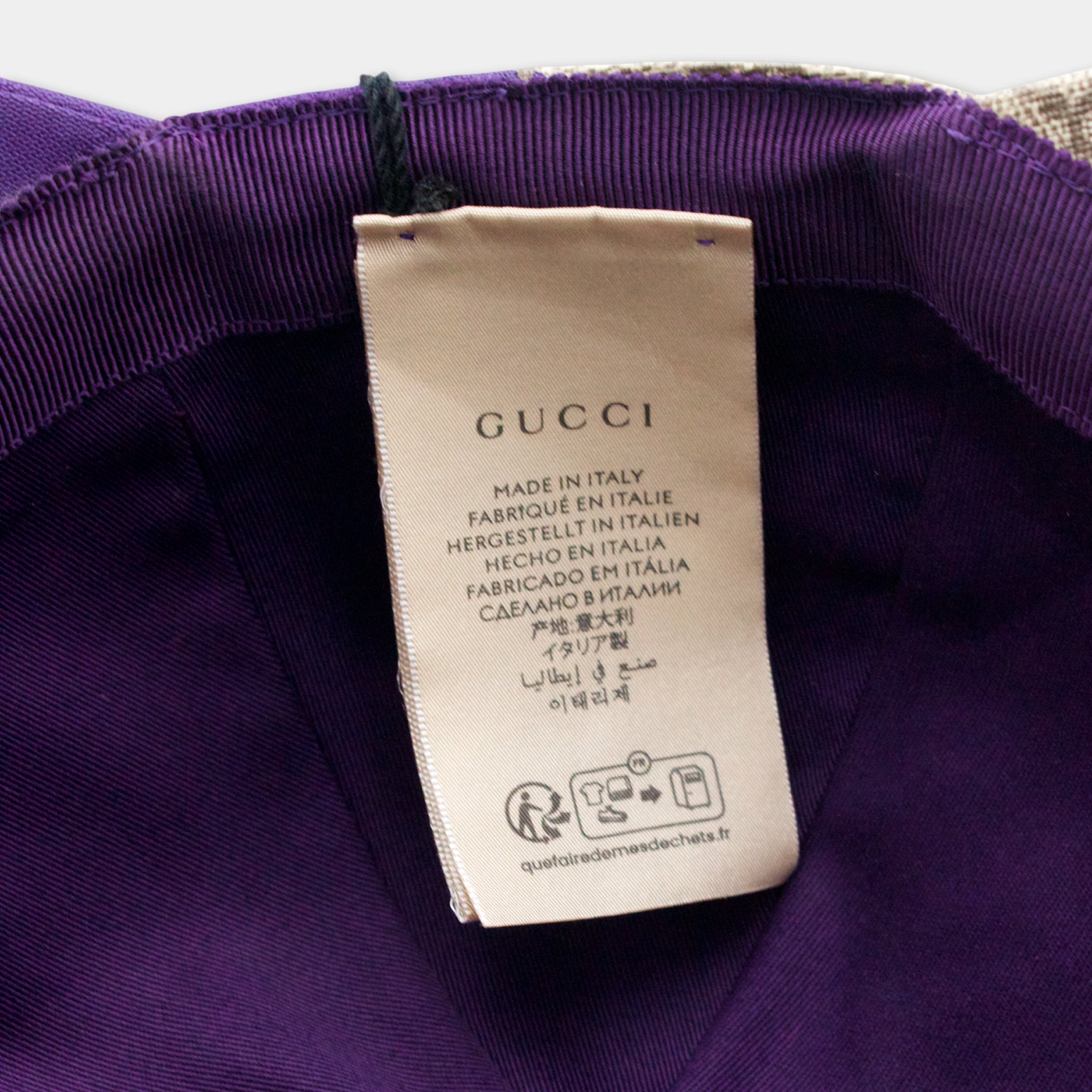 Gucci label on a purple fabric, indicating the brand and its manufacturing origin.