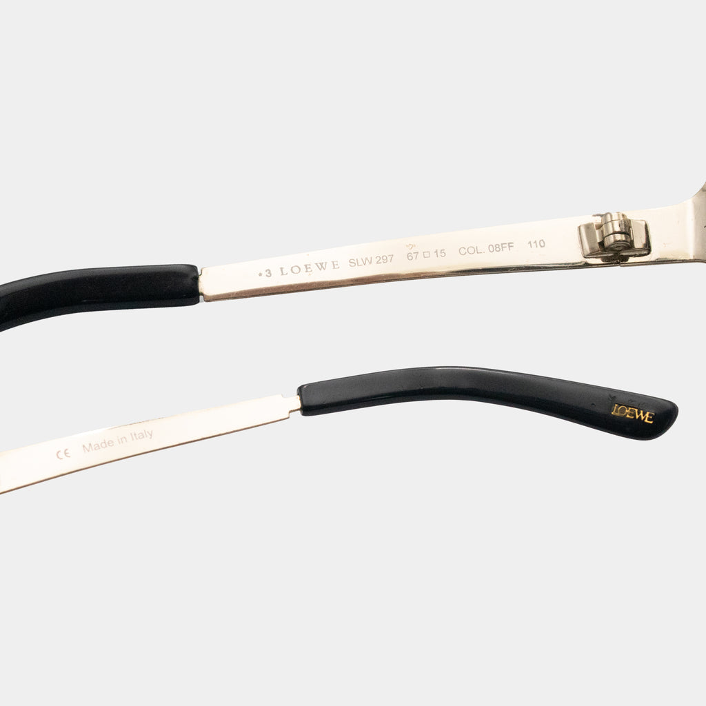 A close-up view of a pair of sunglasses with a black frame and a silver frame, featuring the Lotte brand name and model information.