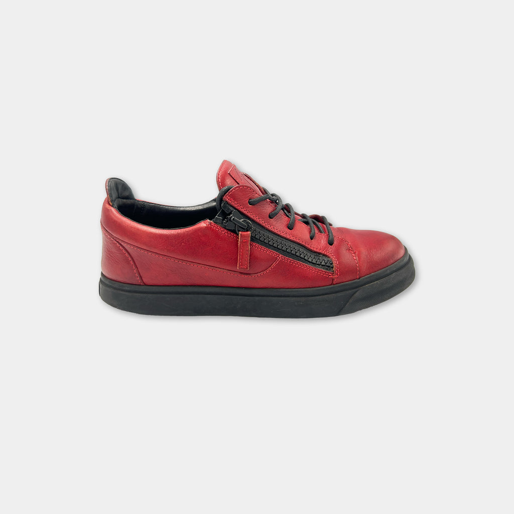 A red and black sneaker with a zipper detail on the side.