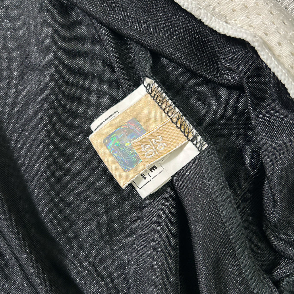 a close-up view of a black fabric, possibly a piece of clothing, with a label attached to it. The label appears to be a price tag or a tag with a barcode.