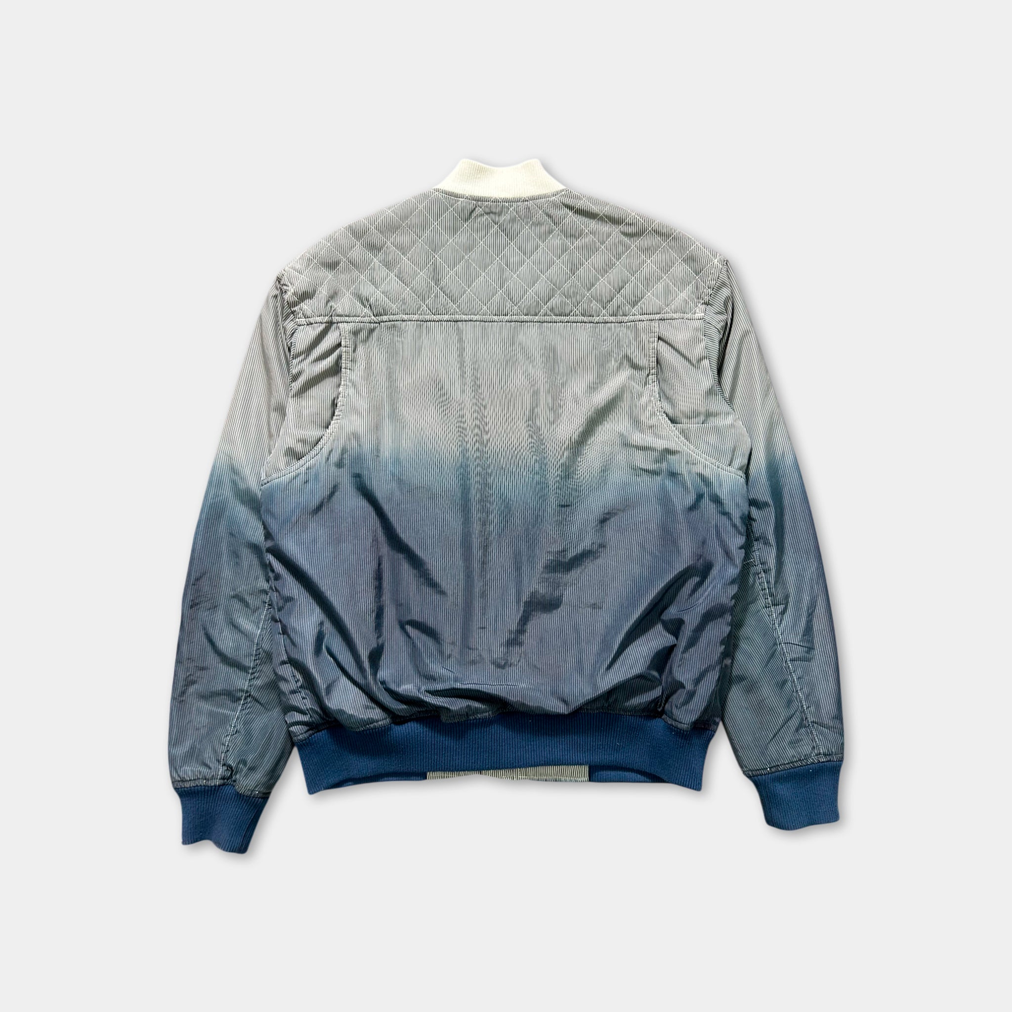 the back view of a gray and blue jacket with a white collar.