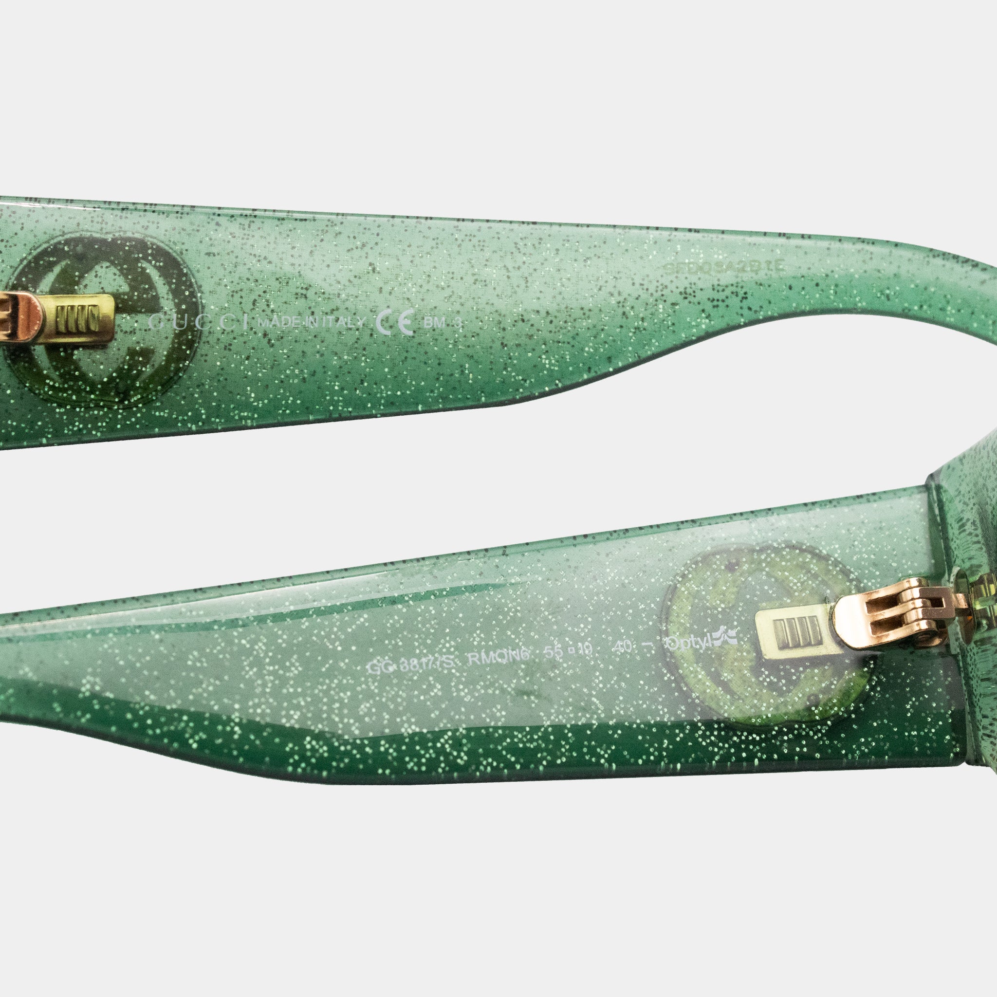 A pair of green glittery sunglasses with gold accents.