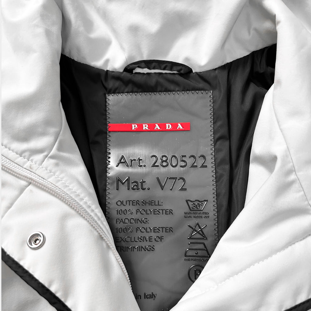 a close-up view of a Prada jacket, focusing on the label that provides information about the jacket's material and features.