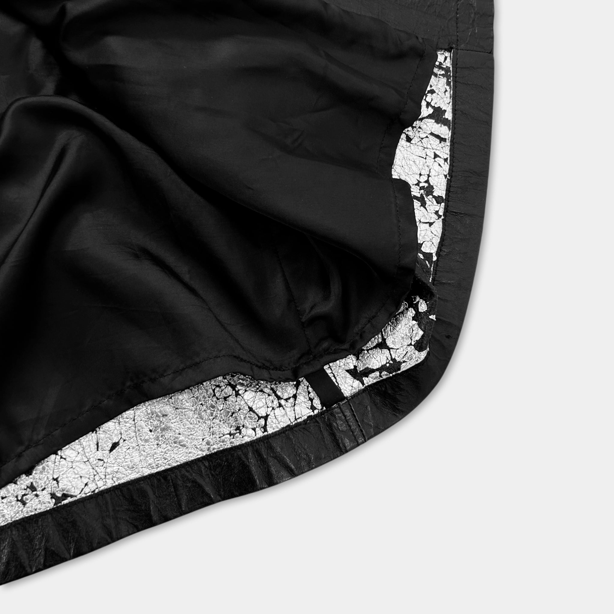 a close-up view of a black fabric with a white pattern or texture, possibly a piece of clothing or a textile.