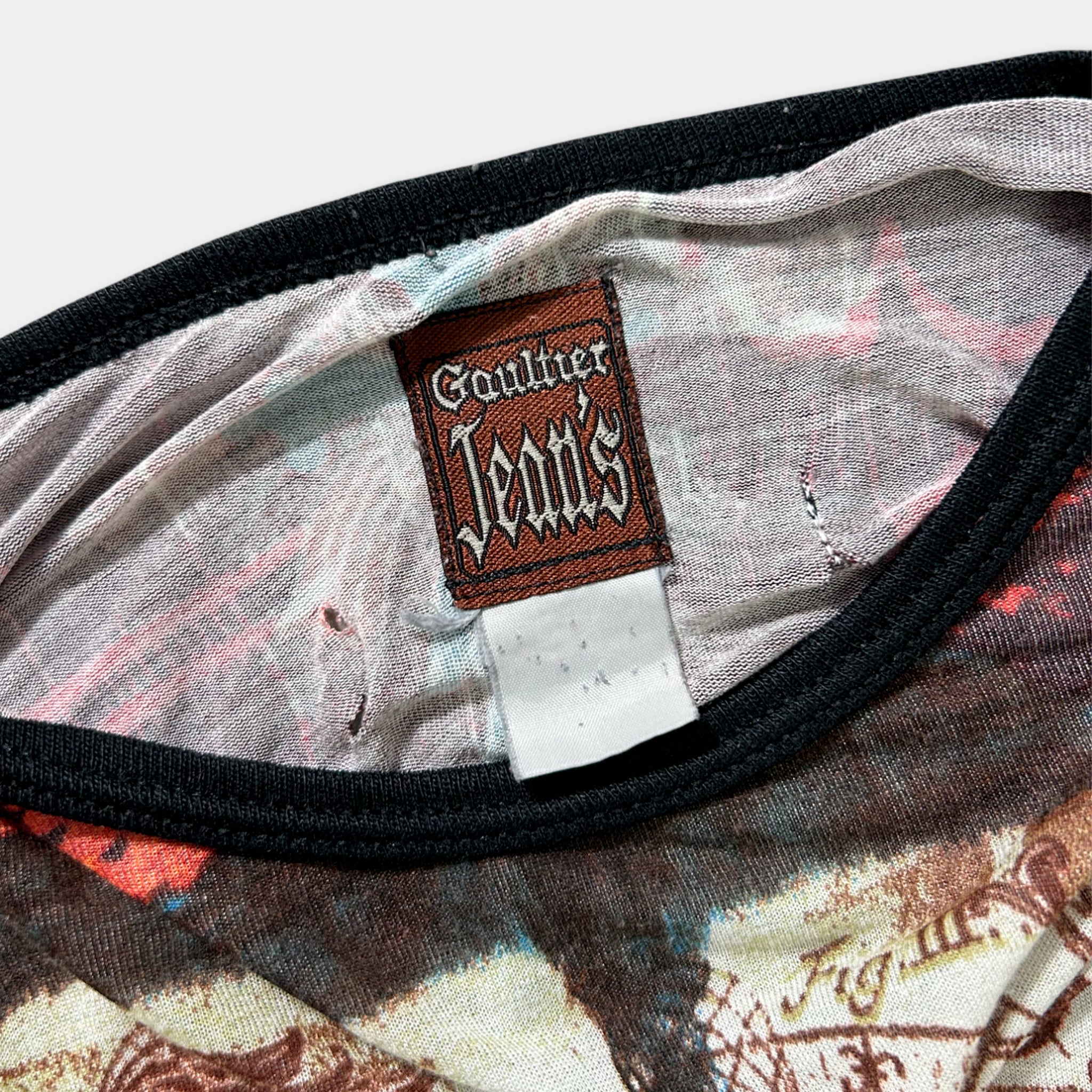 a close-up view of a fabric item, possibly a garment or textile, with a label attached to it. The label appears to be a brand name or description, but it is not clear enough to transcribe accurately.