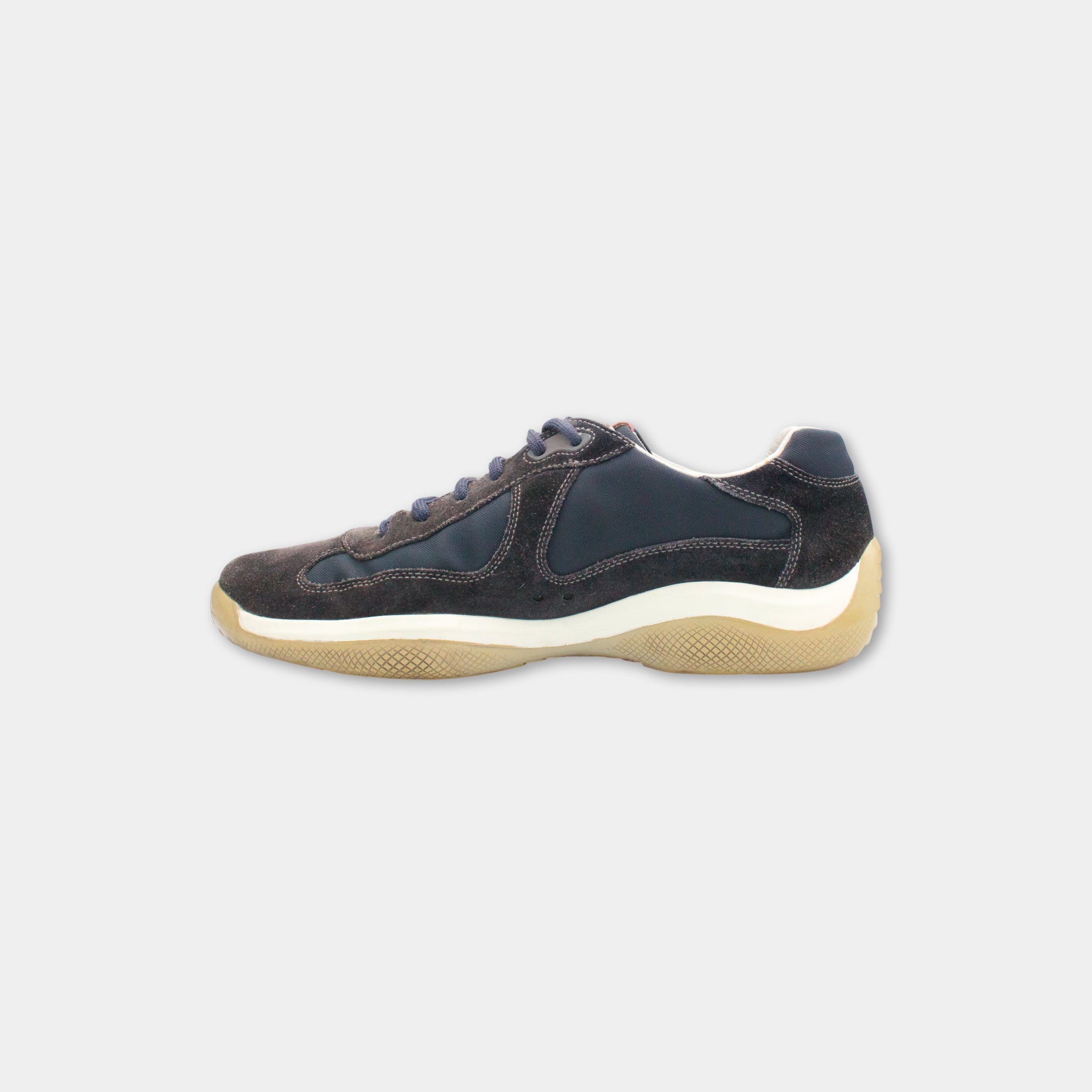 A single, dark blue and white sneaker against a white background.