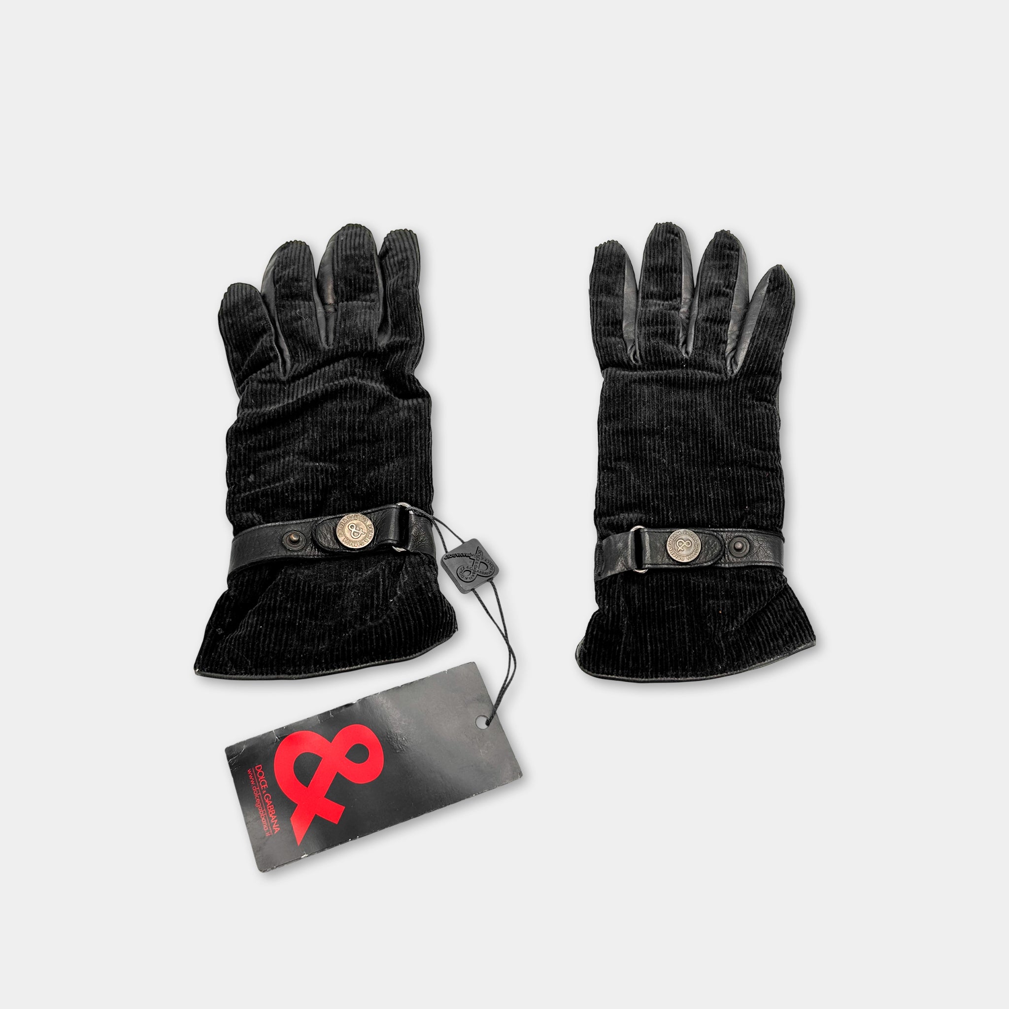 A pair of black gloves with a tag attached, against a white background.