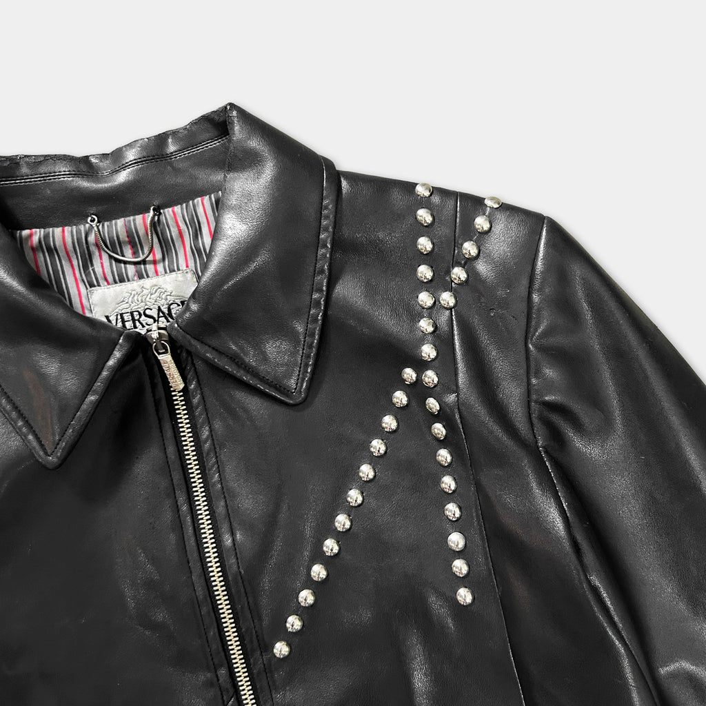 A close-up view of a black leather jacket with silver studs on the sleeves and collar.