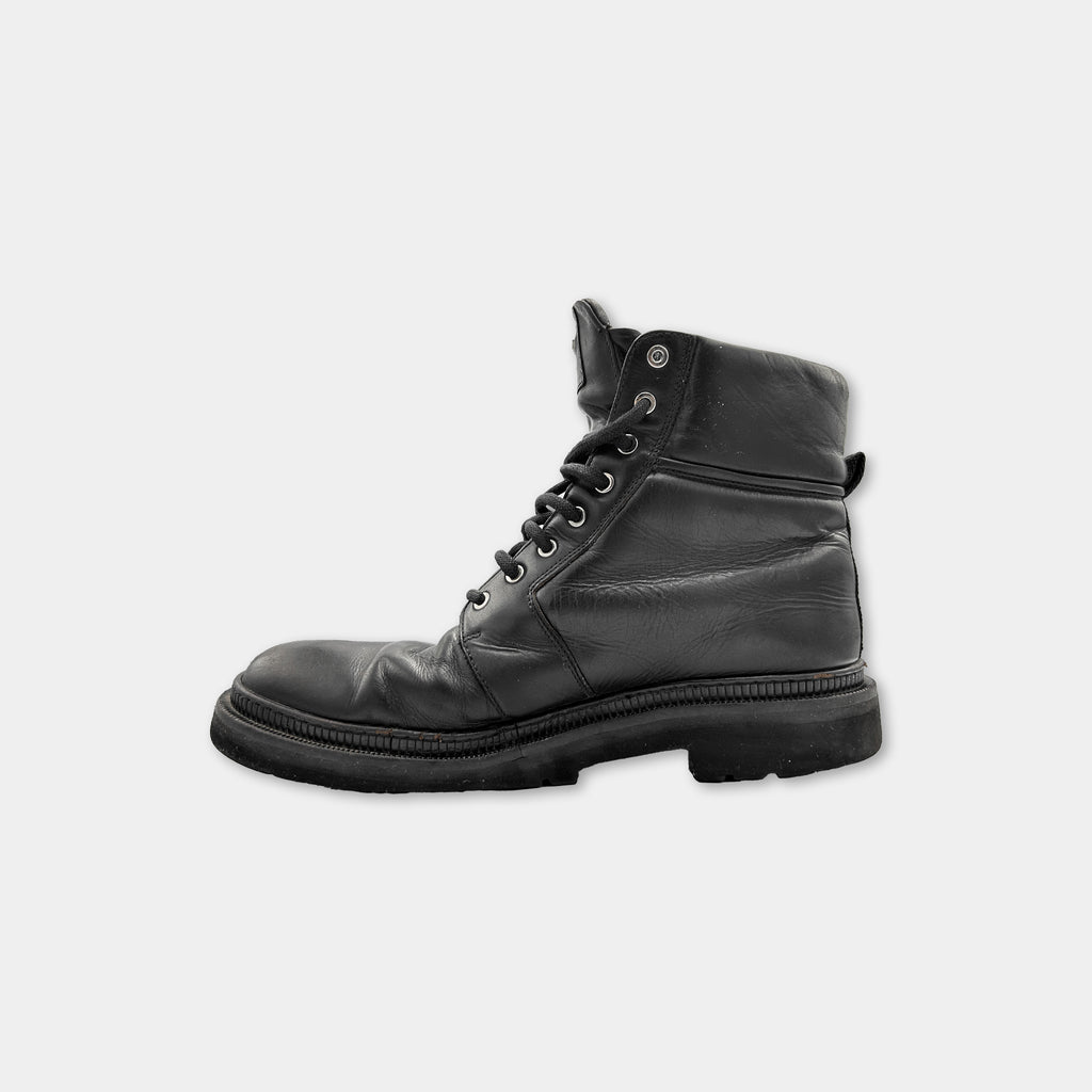 A single black leather boot against a white background.