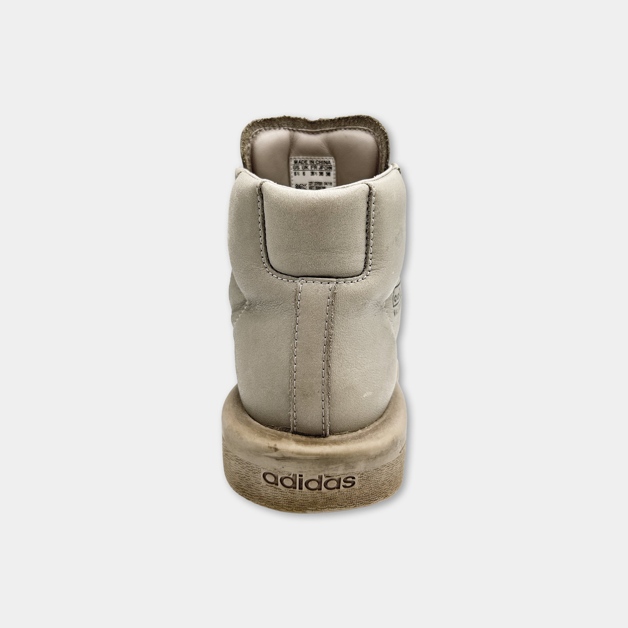 A tan Adidas sneaker with the brand name visible on the sole.