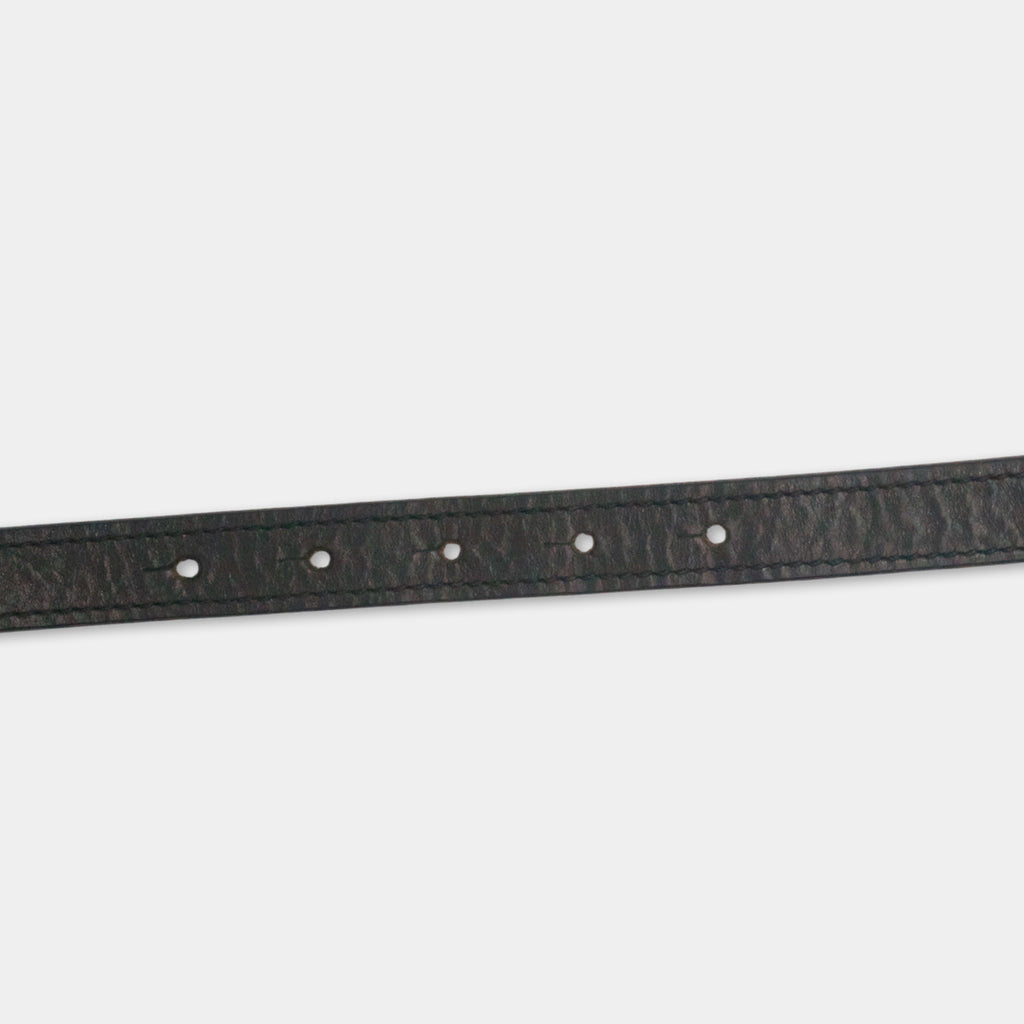 A black leather belt with a row of small holes along the top edge.