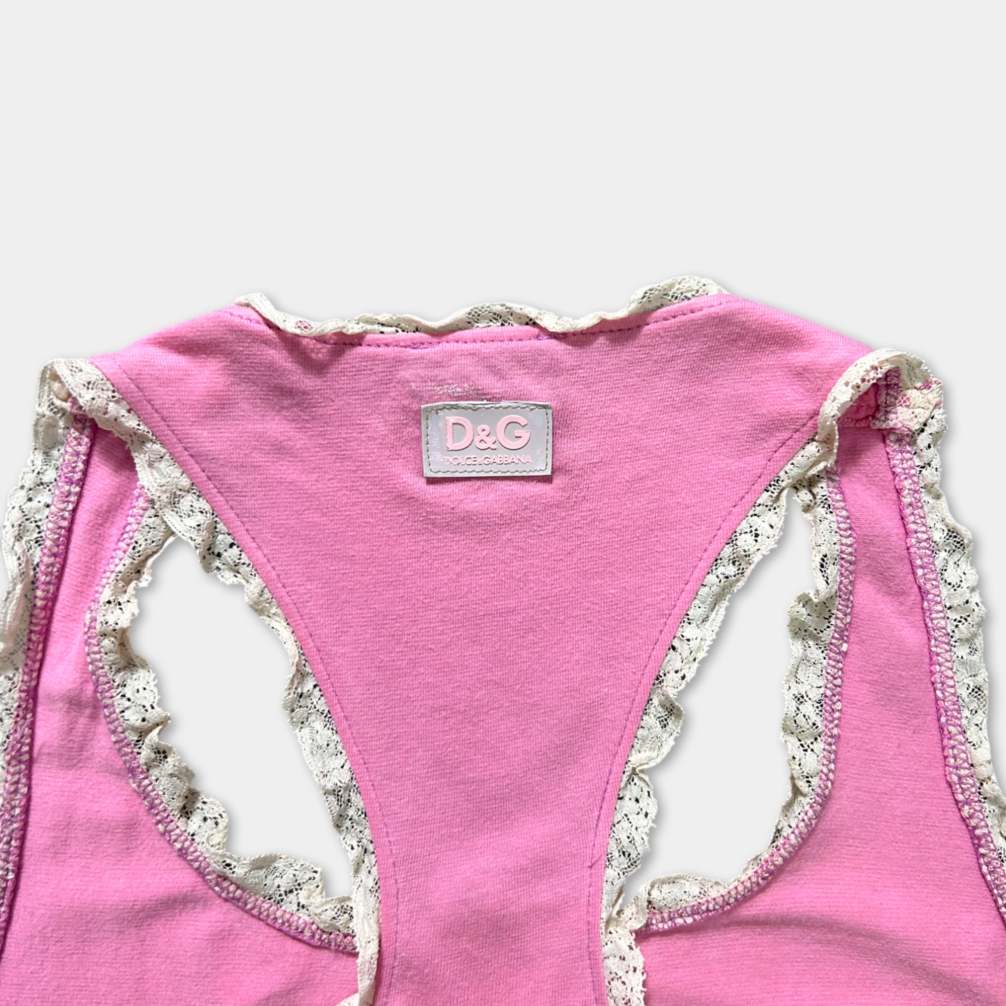 A pink tank top with lace trim and a D&G logo on the back.