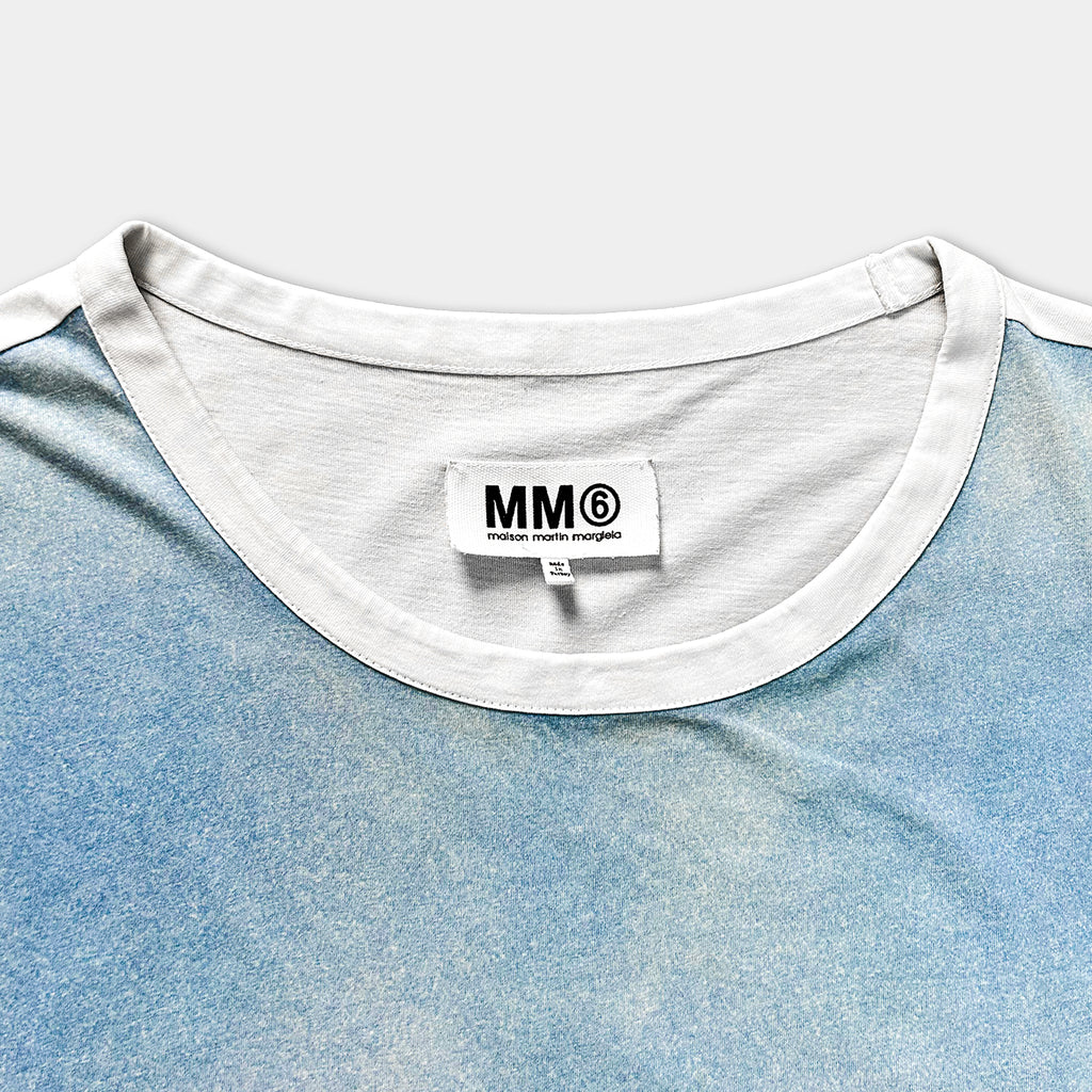 A white collar with a label on a blue shirt.