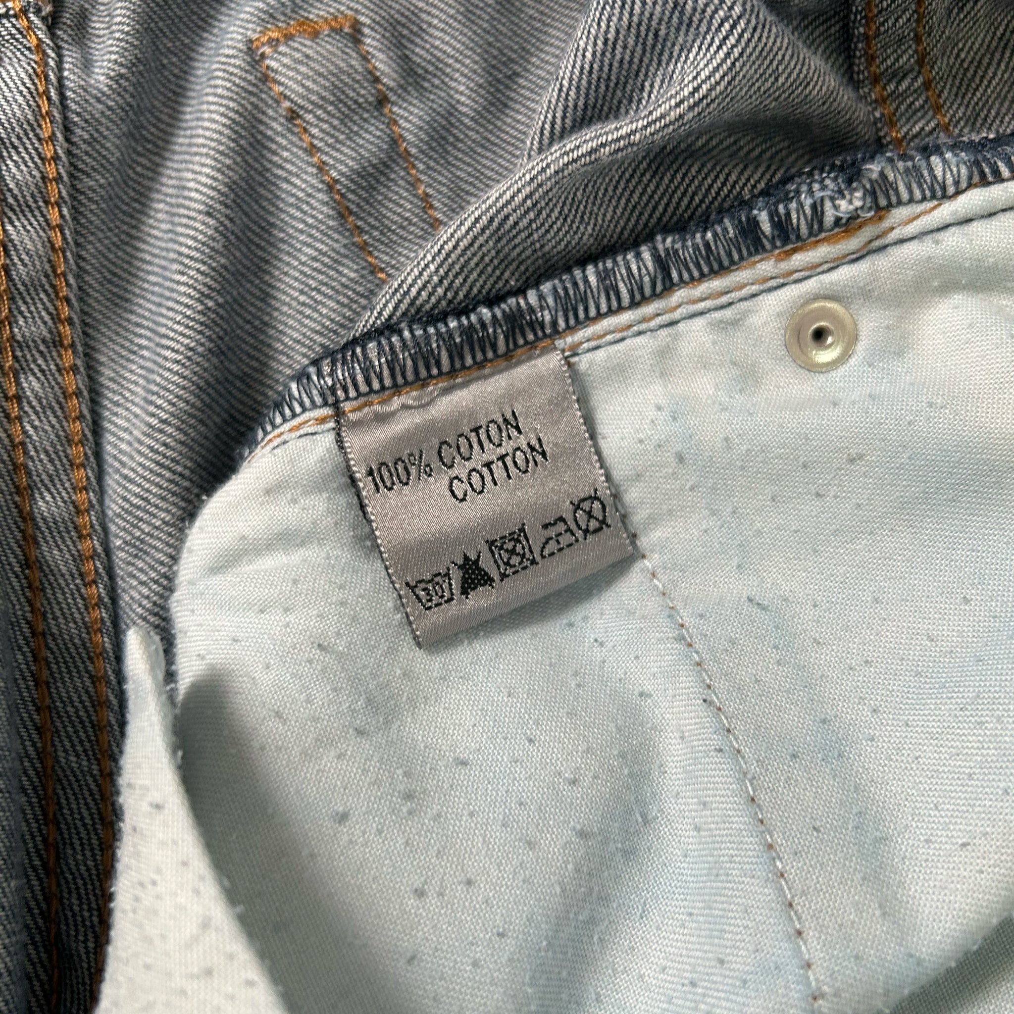 a close-up view of a denim fabric, with a label indicating that it is 100% cotton cotton.