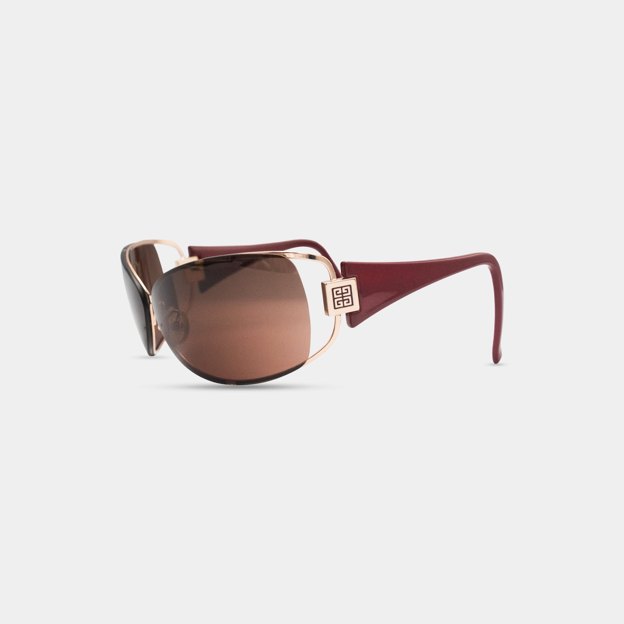A pair of brown sunglasses with a gold frame and a small logo on the frame.