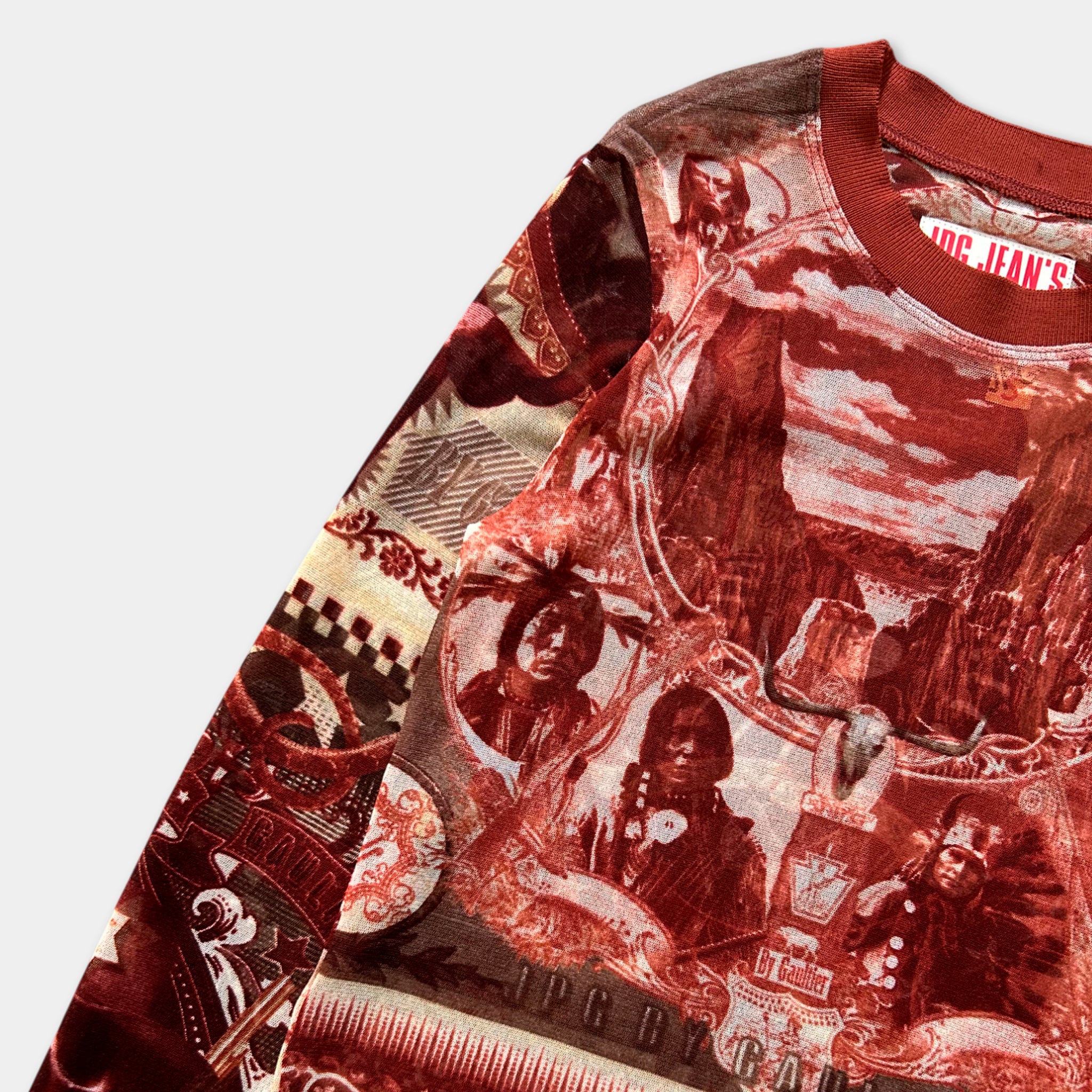 The image is a close-up of a red and white patterned shirt with various images and designs, including people, animals, and landscapes.