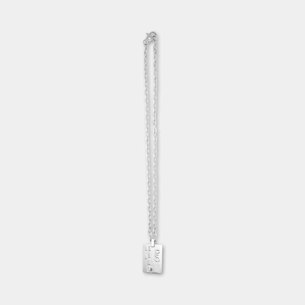 A silver necklace with a rectangular pendant hanging from a chain.