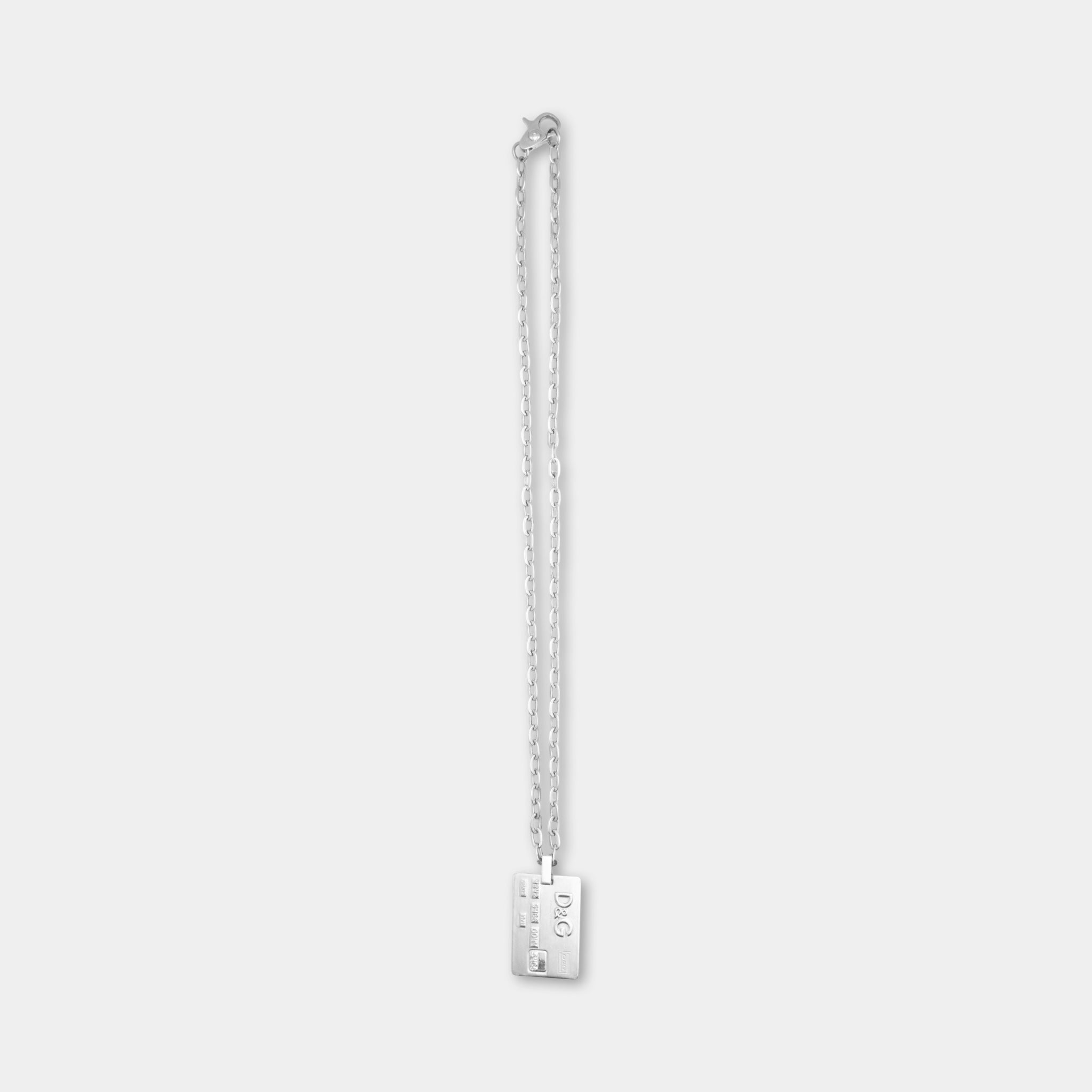 A silver necklace with a rectangular pendant hanging from a chain.