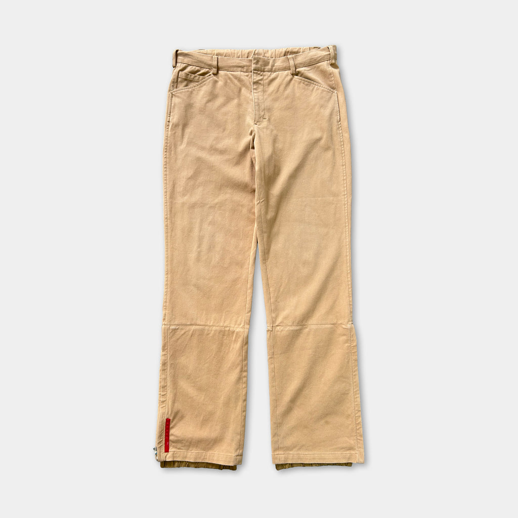A pair of khaki cargo pants with a red zipper detail on the bottom.