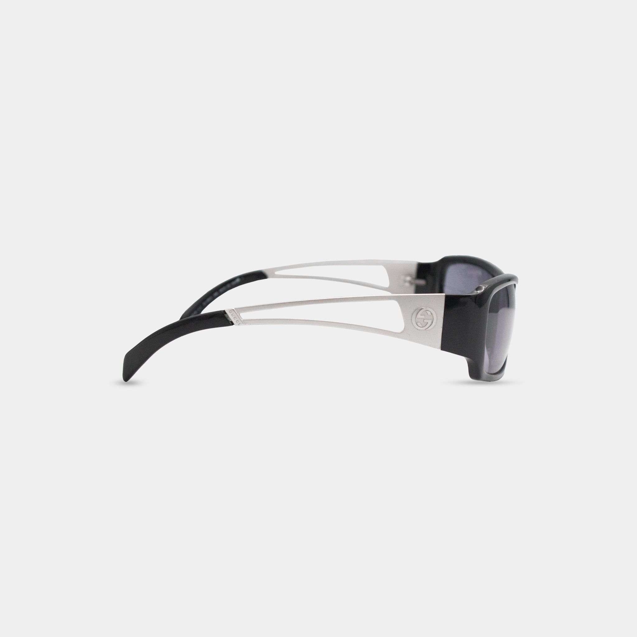 A pair of black and silver sunglasses with a distinctive Gucci logo on the frame.