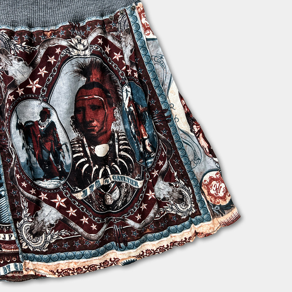 a skirt with a colorful, intricate design. The design includes a central image of a person with a distinctive hairstyle, surrounded by various decorative elements and patterns.