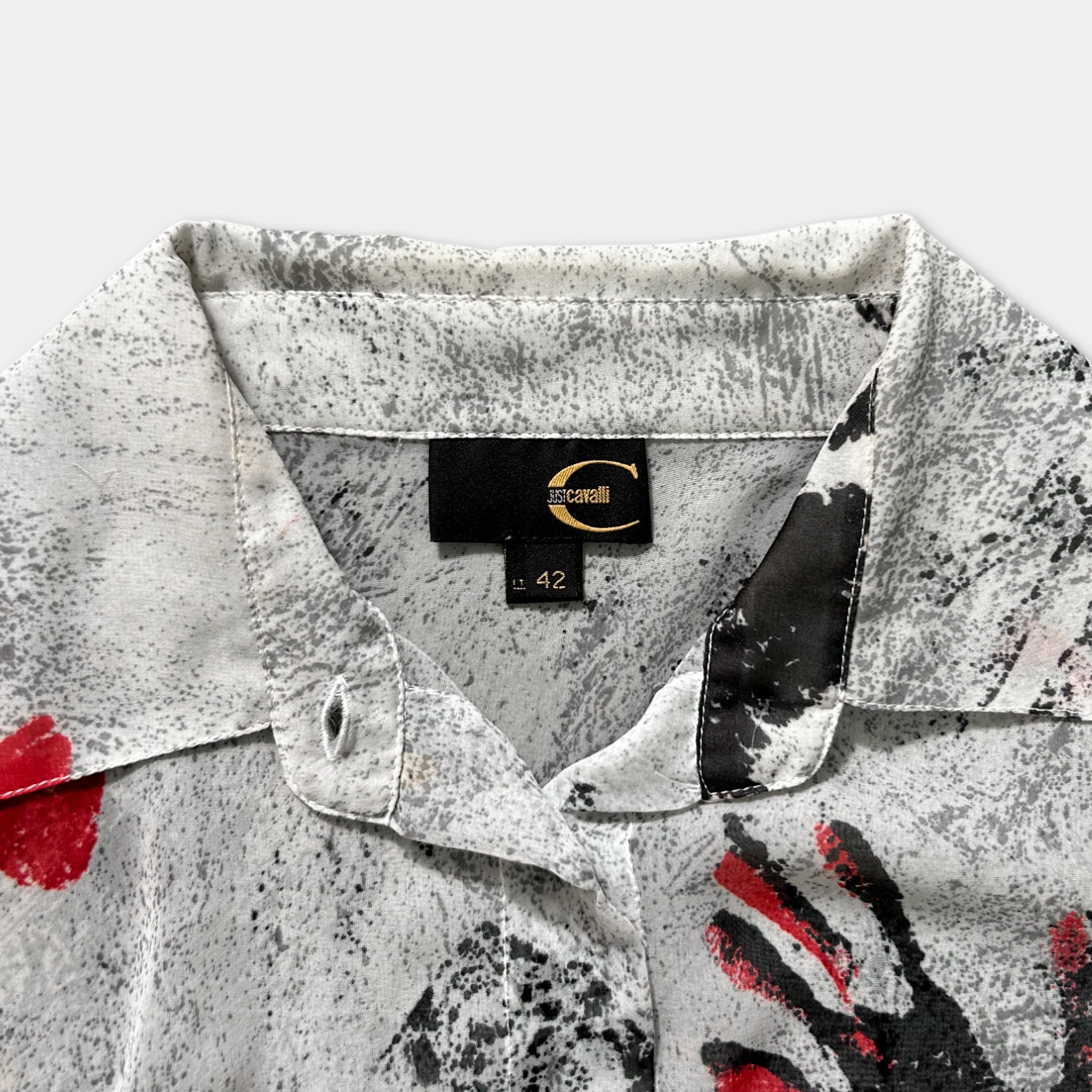 a close-up view of a white and black patterned shirt collar, with a label indicating the brand and size.