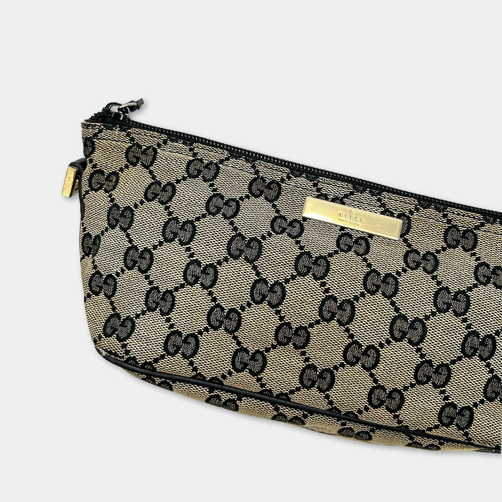 A black and gold Gucci-branded handbag with a distinctive monogram pattern.