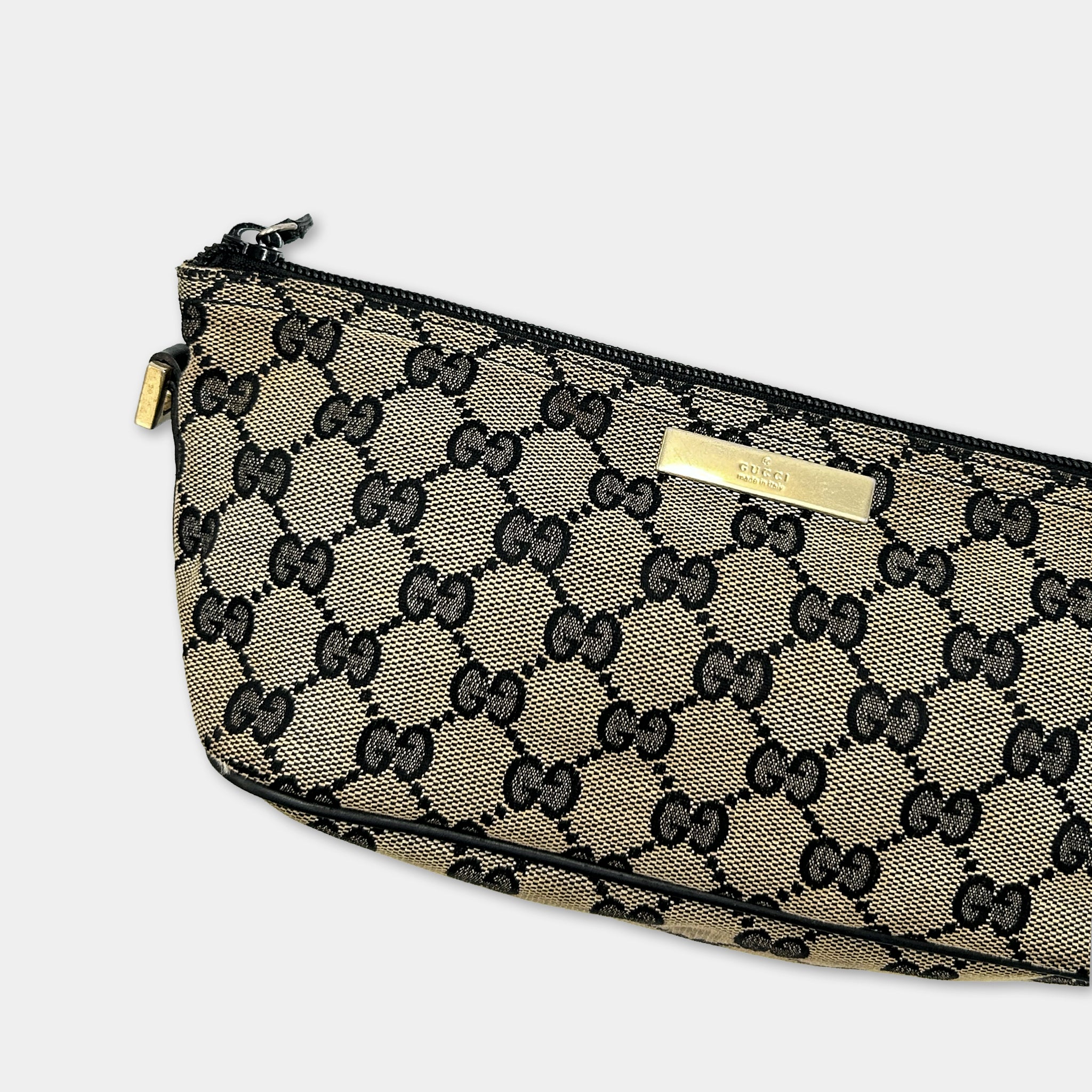 A black and gold Gucci-branded handbag with a distinctive monogram pattern.