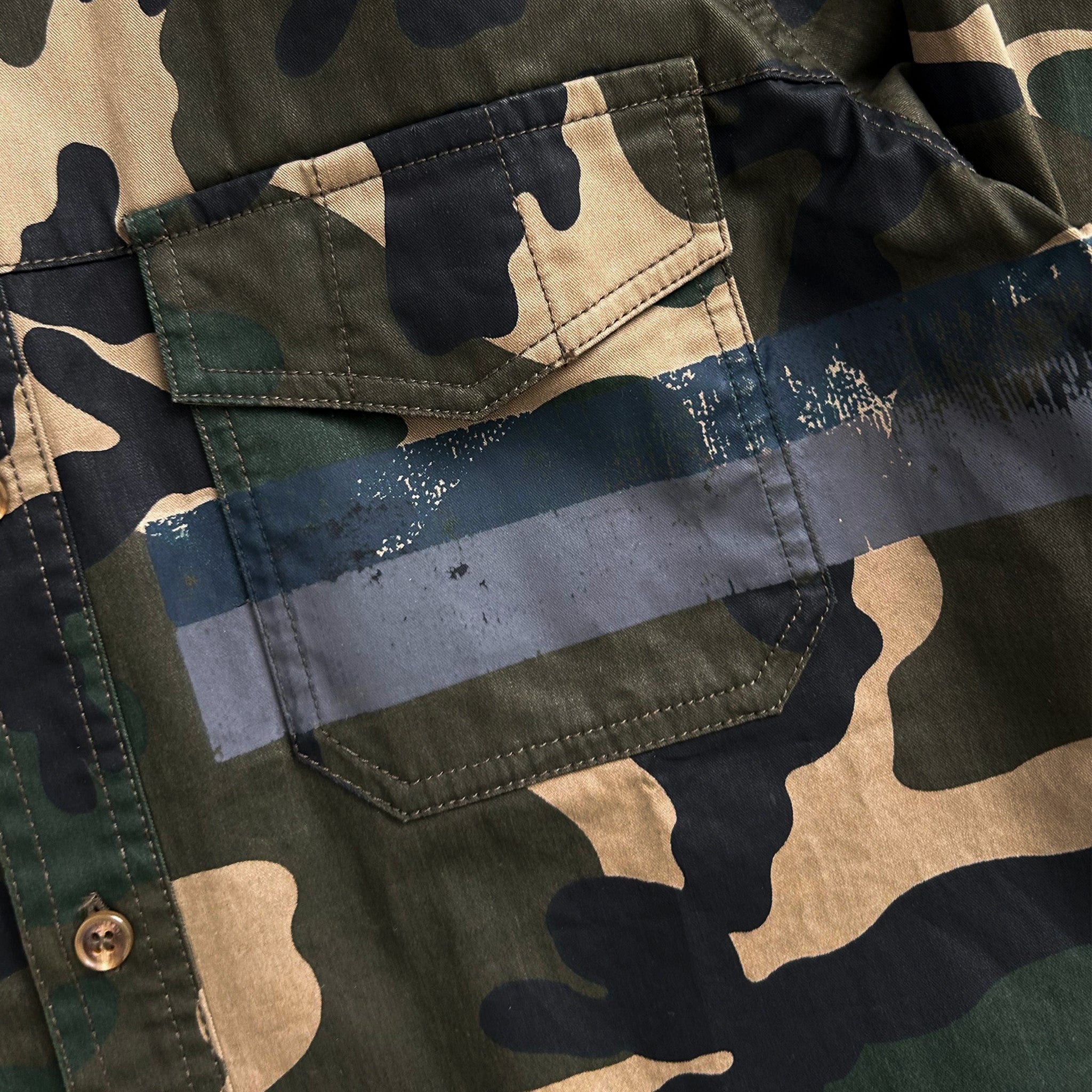 a close-up view of a camouflage pattern on a fabric, with a focus on the pocket area.