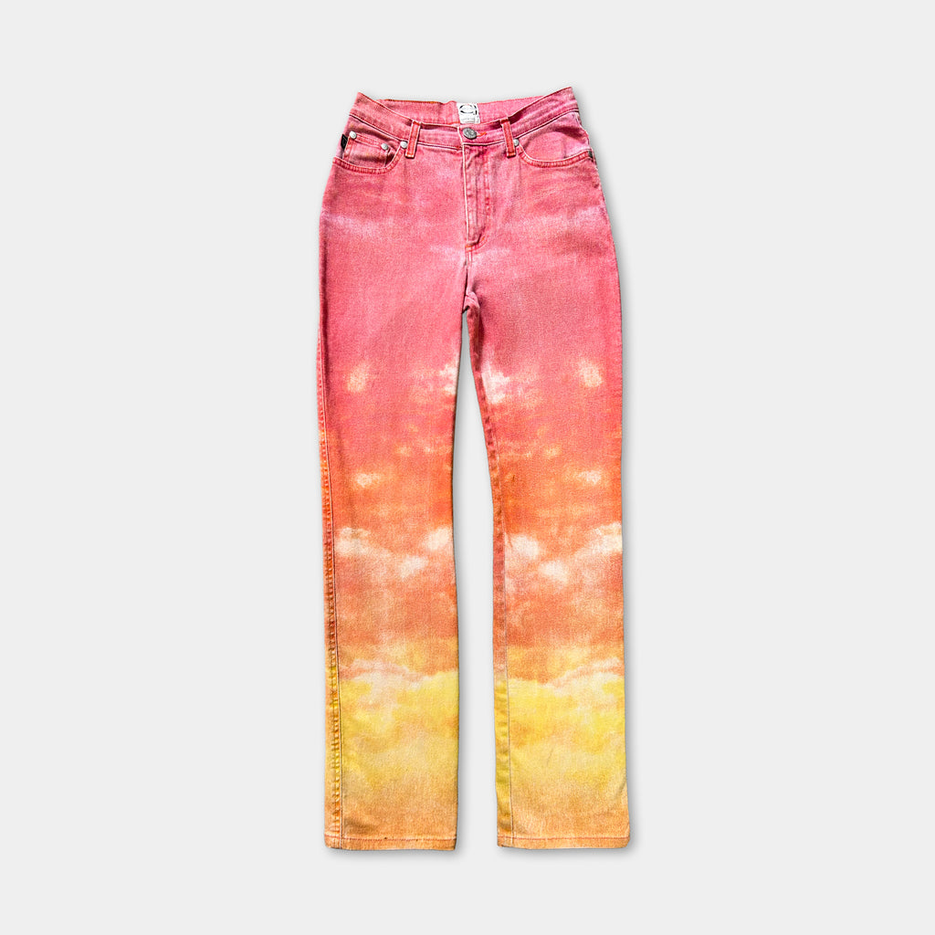 A pair of high-waisted, tie-dye jeans with a vibrant gradient of pink and orange colors.