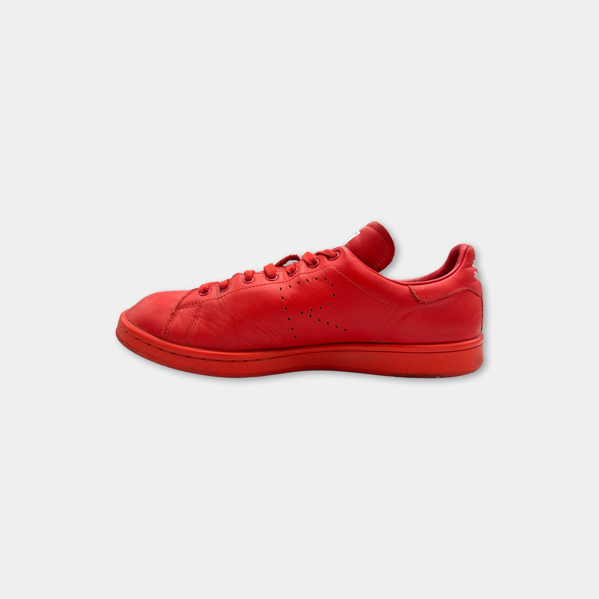 A single red sneaker with a distinctive logo on the side.