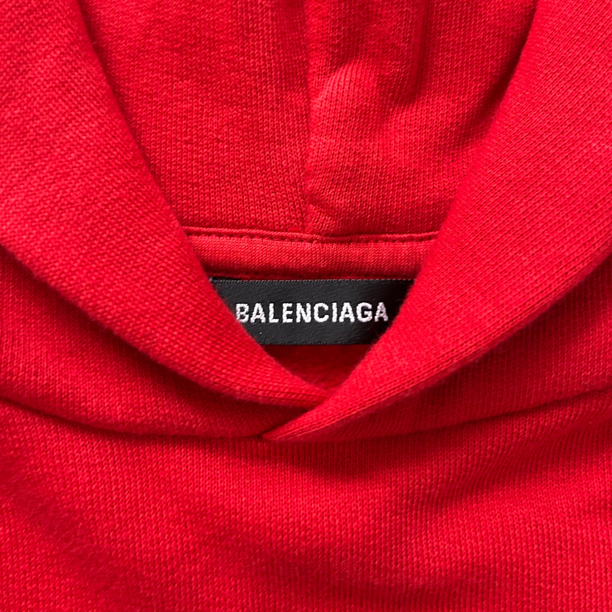A close-up view of a red hoodie with a label that reads "BALENCIA".