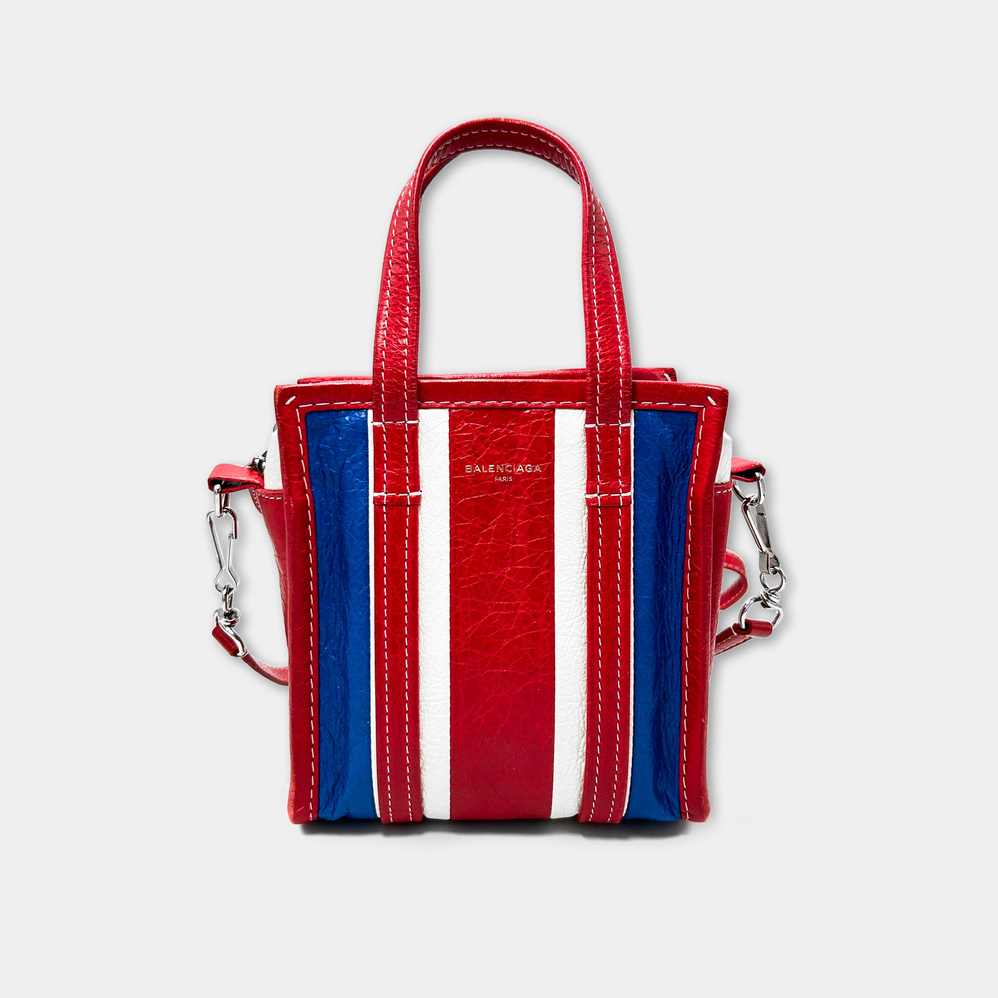 A red, white, and blue striped handbag with the Balenciaga logo on it.