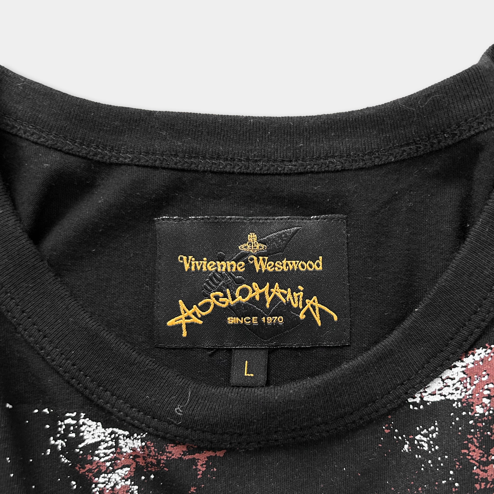 a close-up view of a black t-shirt with a label on the collar, displaying the brand name and the year of production.