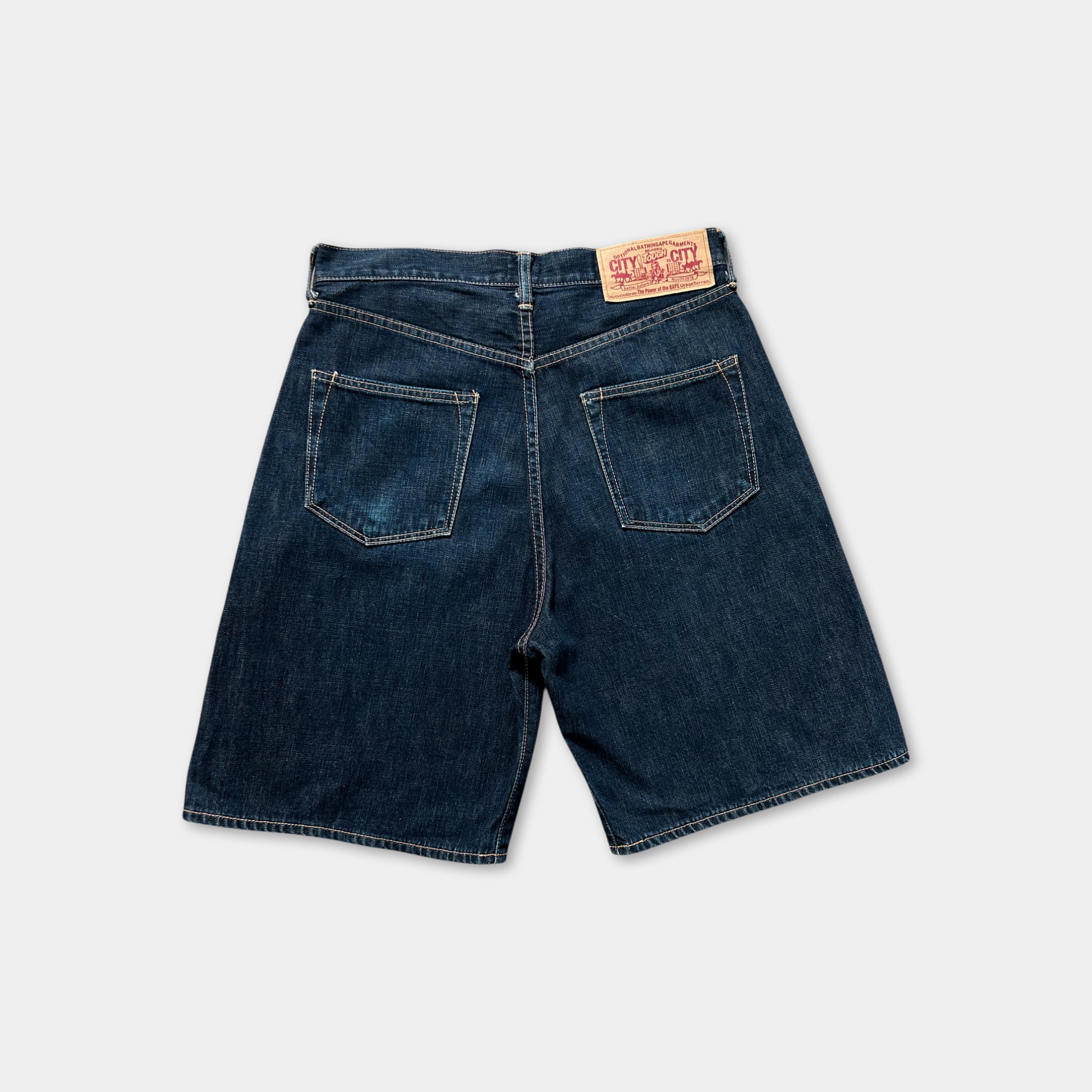 A pair of blue denim shorts with a red and white label on the waistband.