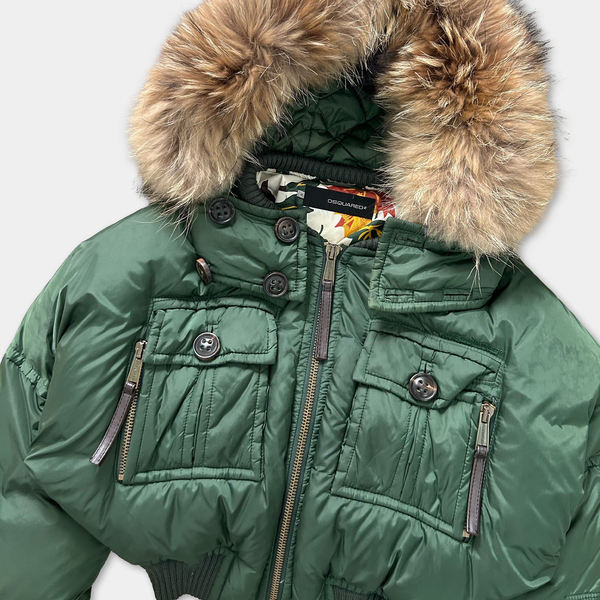 A green puffy jacket with a fur-trimmed hood, zipper, and pockets.