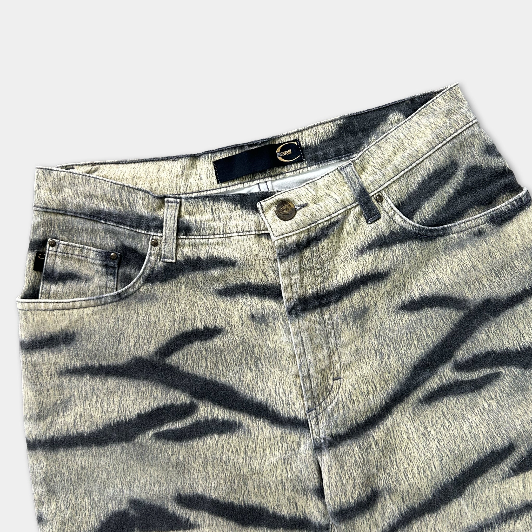A pair of gray and black zebra-striped jeans with a black belt and zipper.