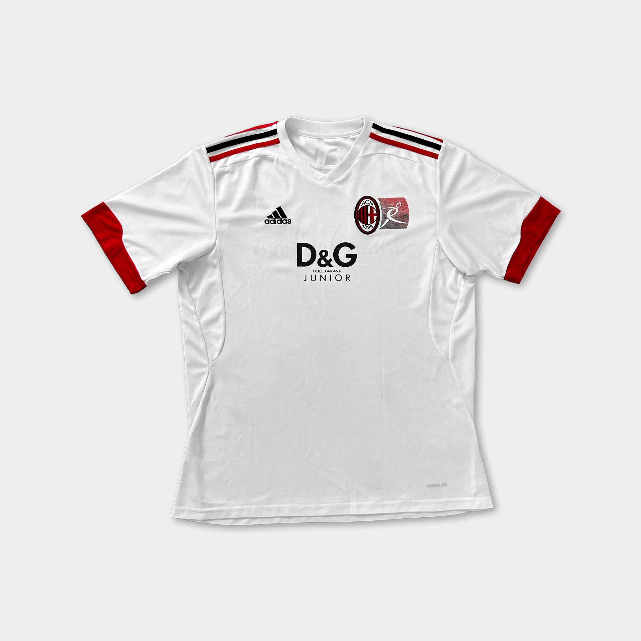 A white soccer jersey with red accents, featuring the Adidas logo and the Junior logo.