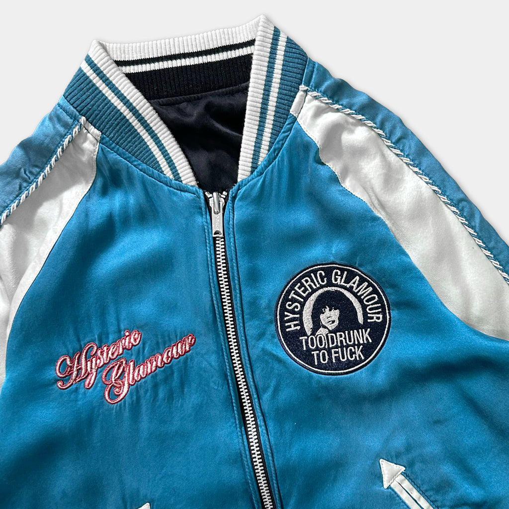 A blue and white jacket with a zipper and a circular patch on the front.