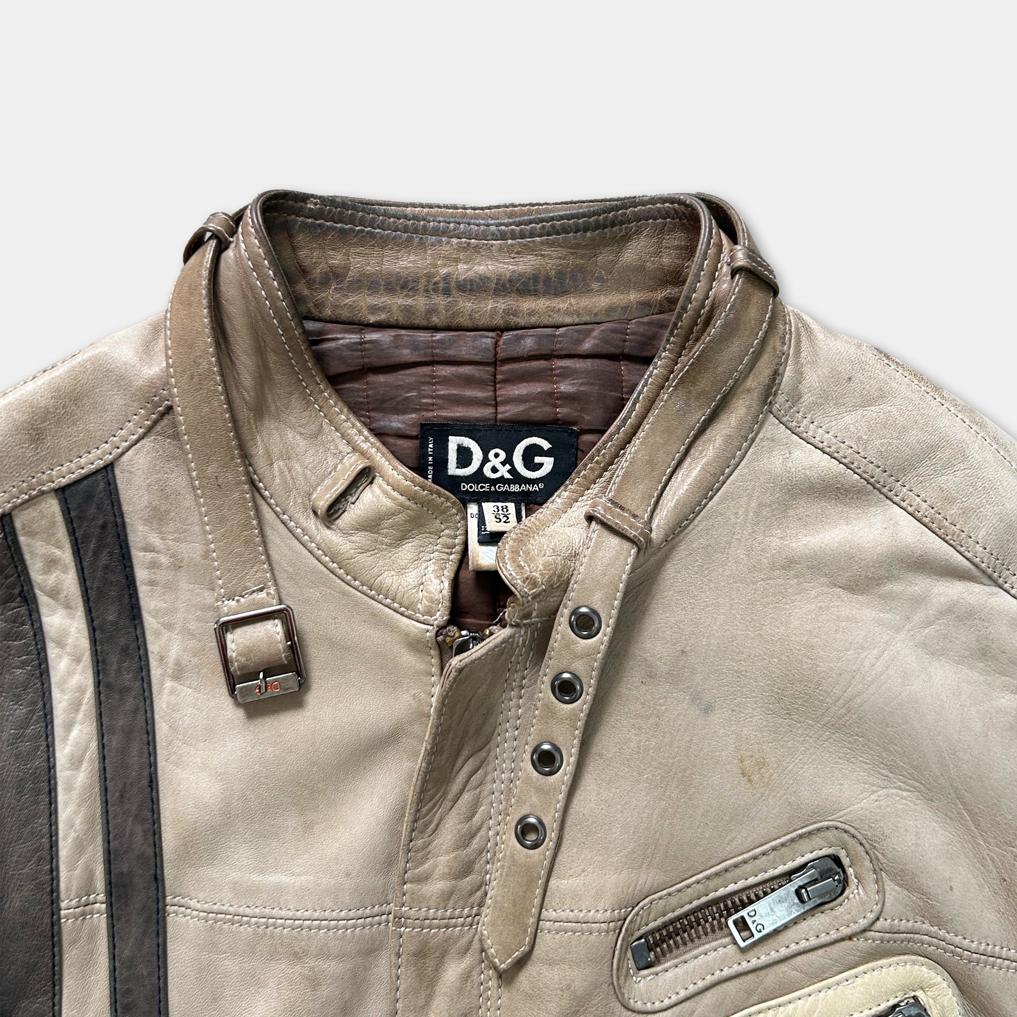 A tan leather jacket with a brown collar and a D&G logo on the chest.