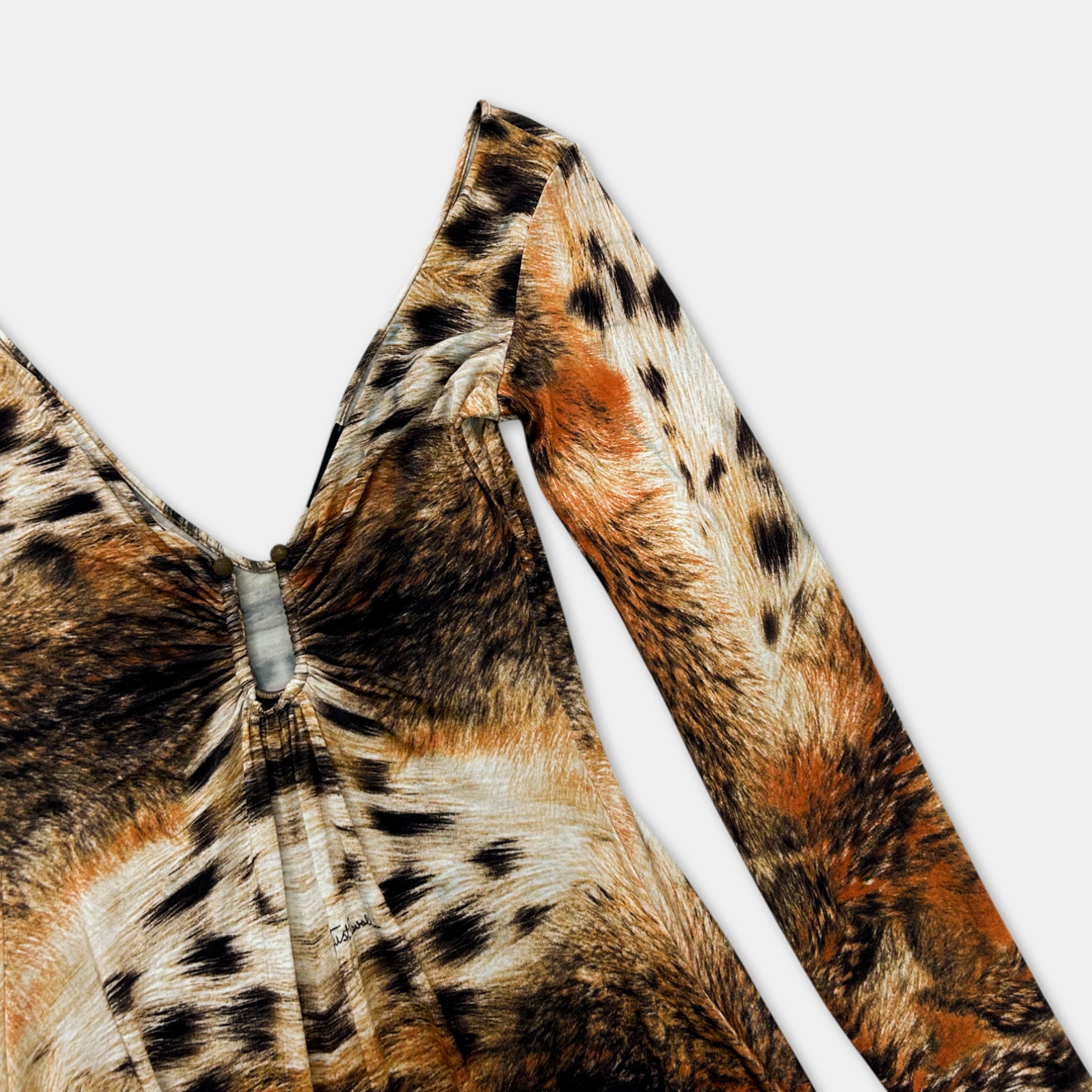 A close-up view of a leopard print dress with a distinctive pattern of brown and orange spots.