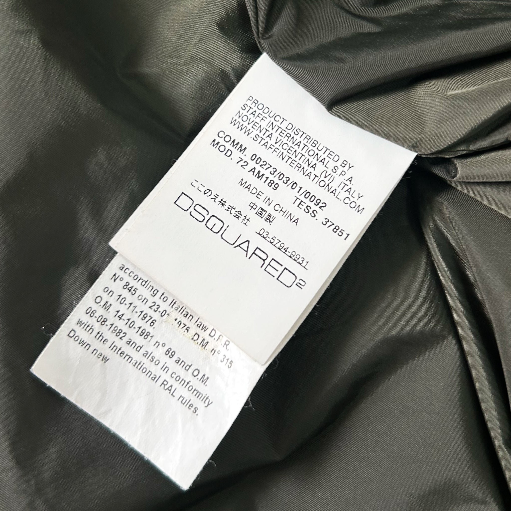 a close-up view of a label on a piece of clothing, likely a jacket or coat, with text and information about the product.