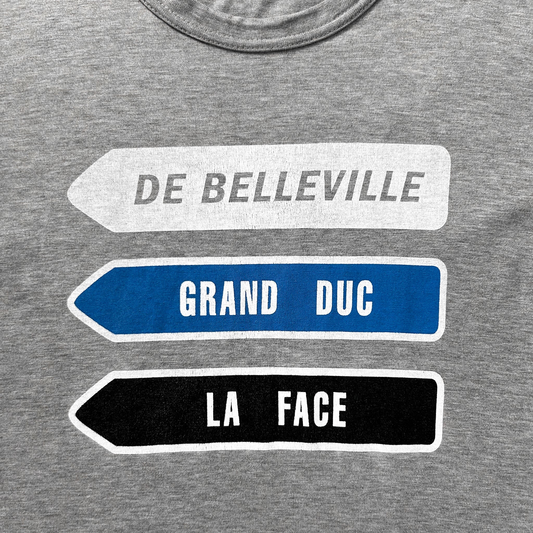 a gray t-shirt with three directional signs pointing in different directions, each with a different color and text.