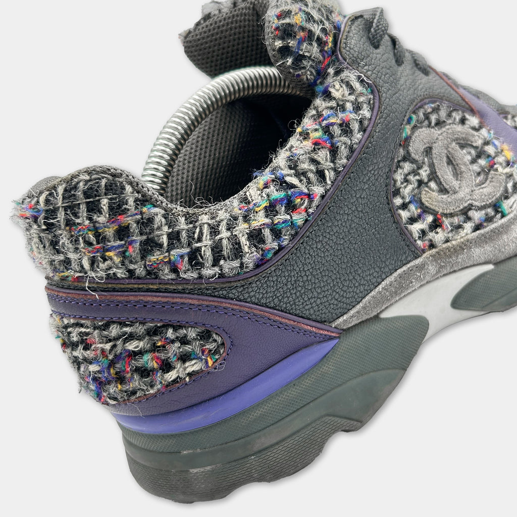 A close-up view of a Chanel sneaker with a distinctive woven pattern and a purple accent.