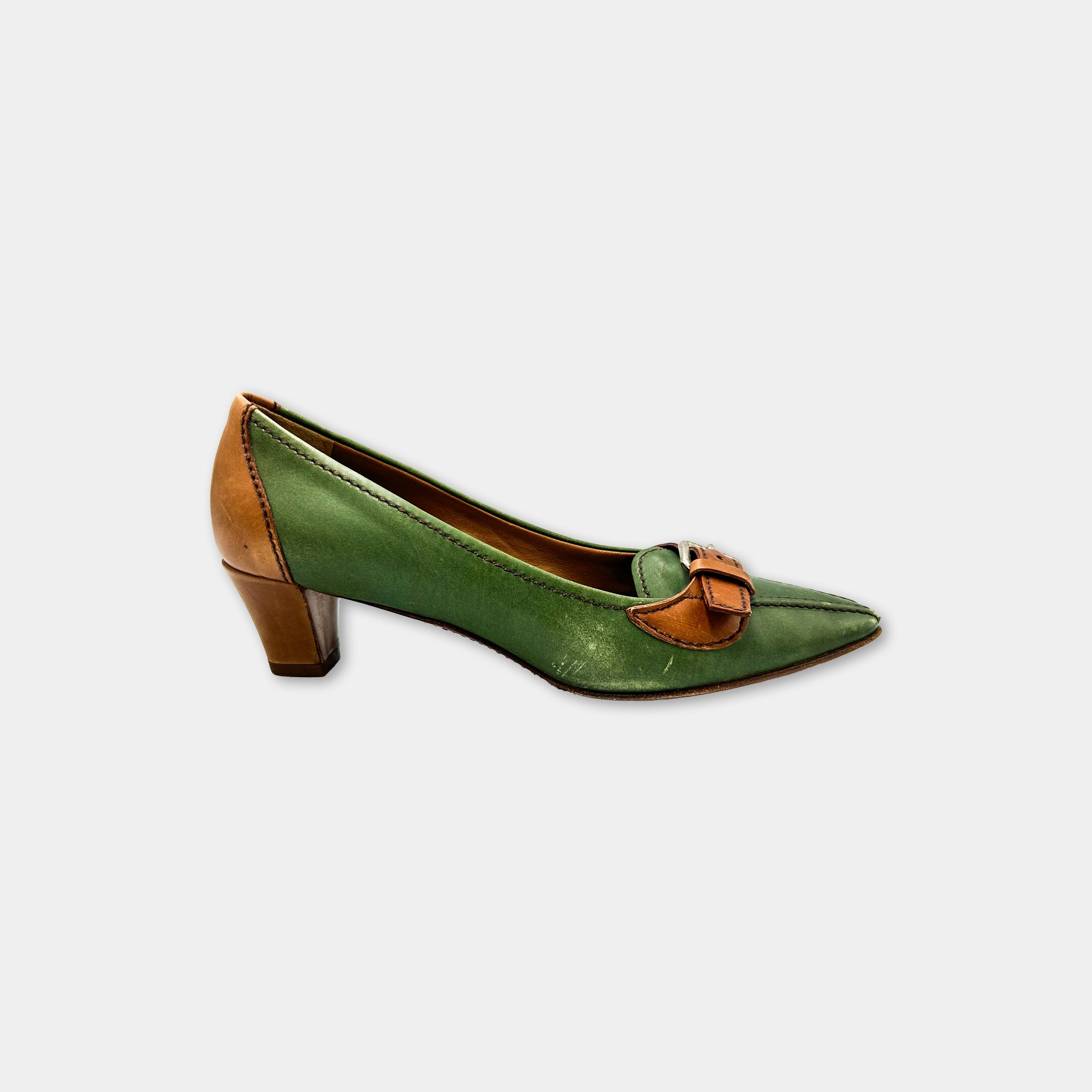 A green and brown high-heeled shoe with a pointed toe and a small buckle detail.