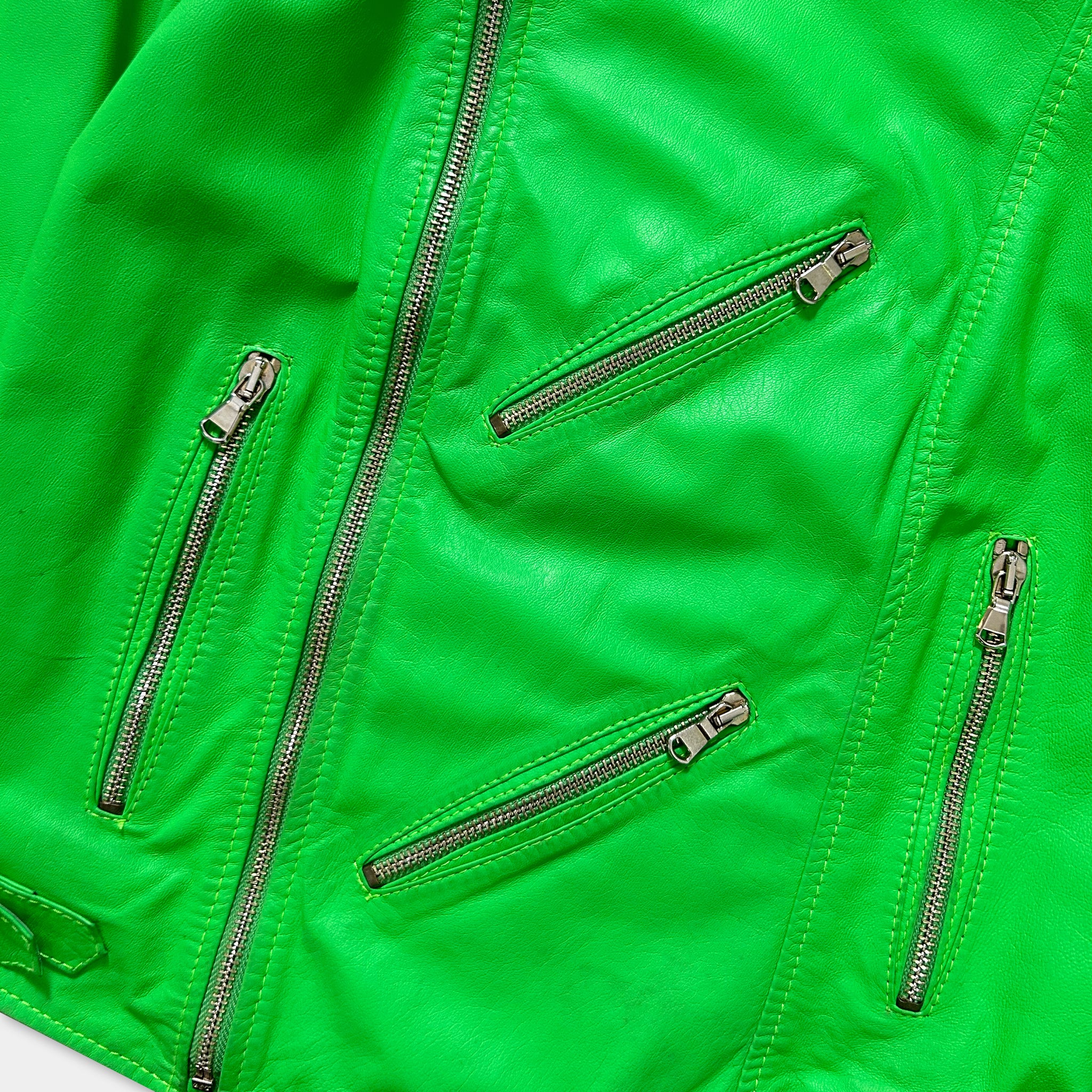 A close-up view of a bright green leather jacket with multiple zippers and pockets.
