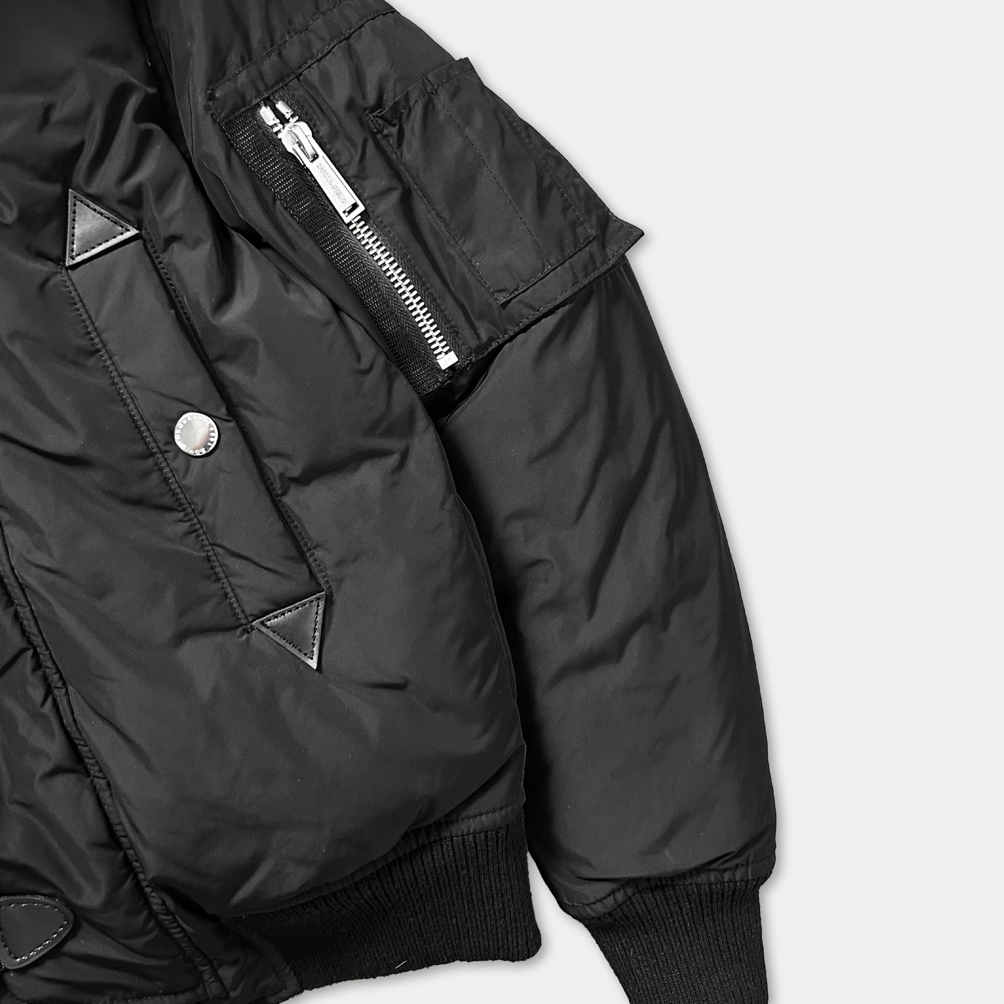 A close-up view of a black jacket with a zipper and pockets, showing the details of the jacket's design.
