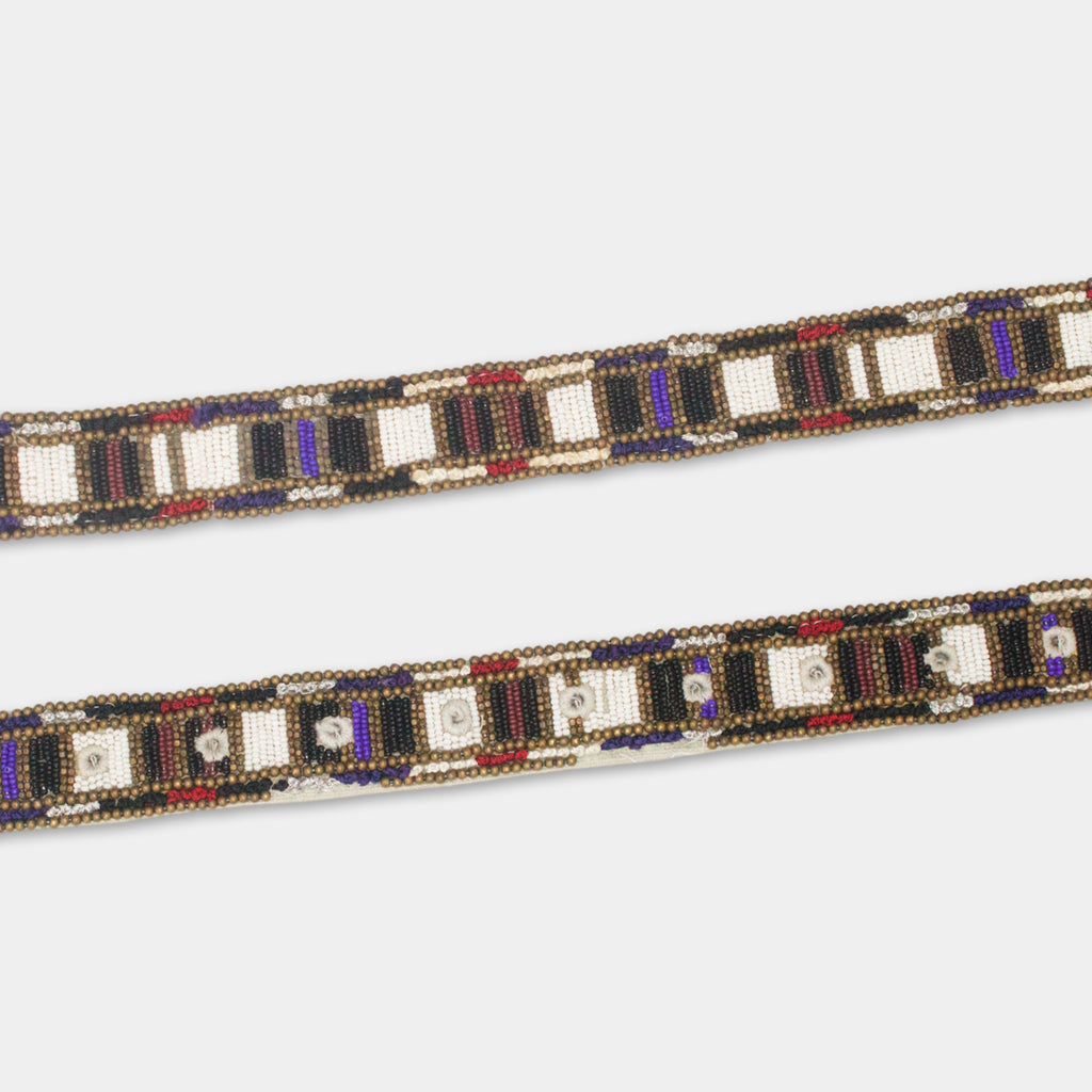 a decorative beaded belt with a repeating pattern of black, white, and red beads arranged in a diagonal line.