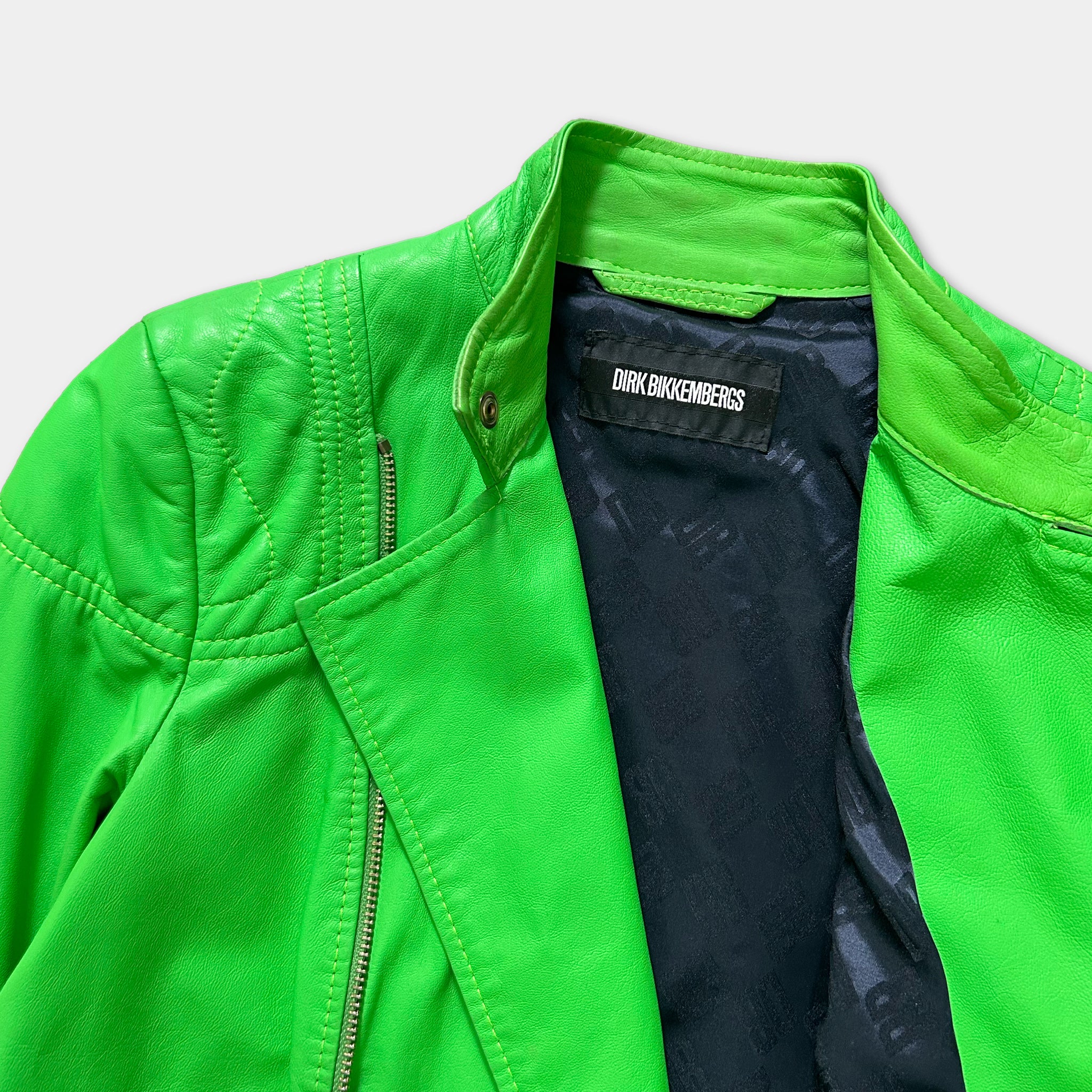 A bright green leather jacket with a black label on the collar.