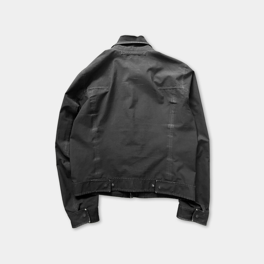 a black jacket with a collar and zipper, laid out flat against a white background.